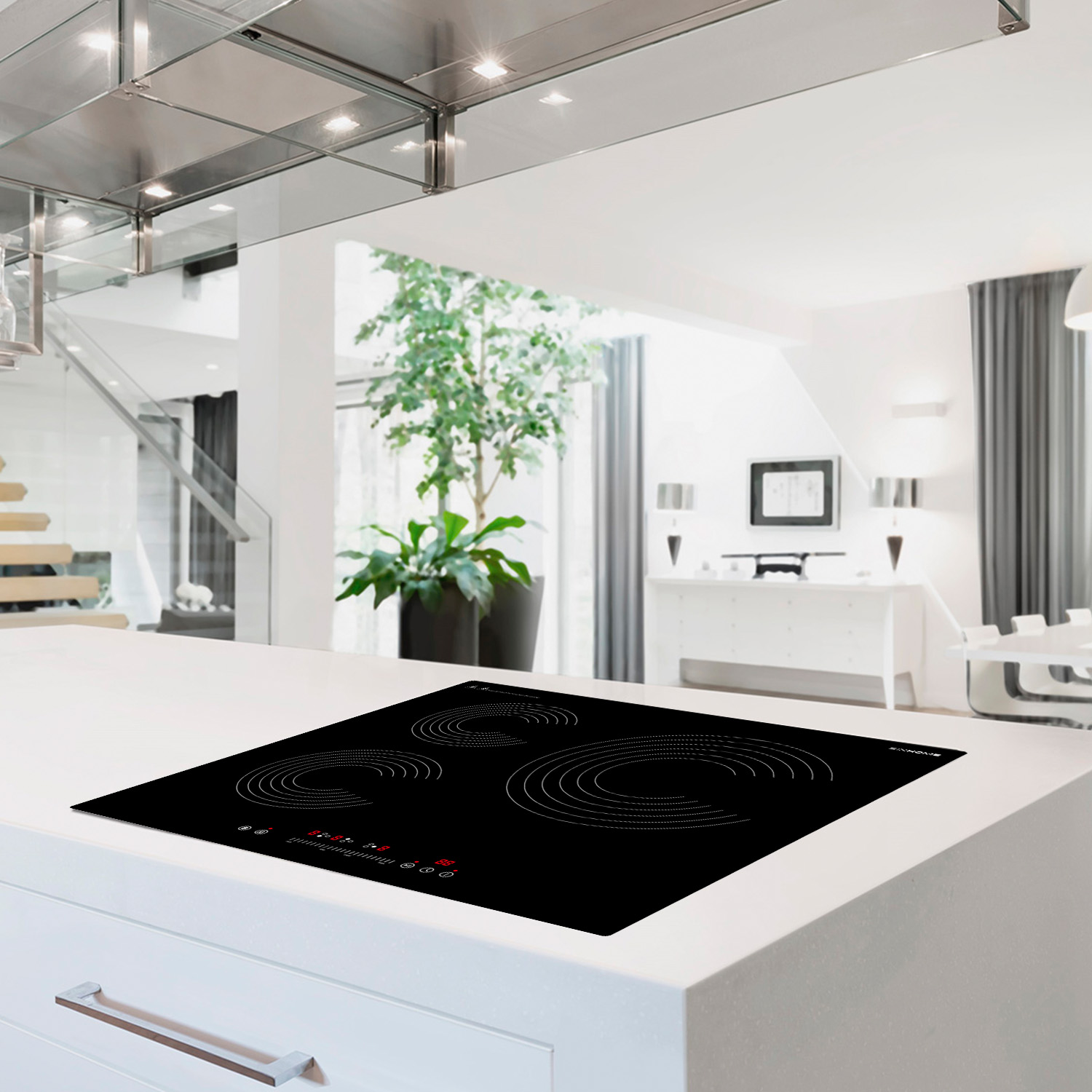 Una isla de cocina moderna con una placa de cocina negra. El fondo revela un espacio vital brillante con una planta y escaleras.