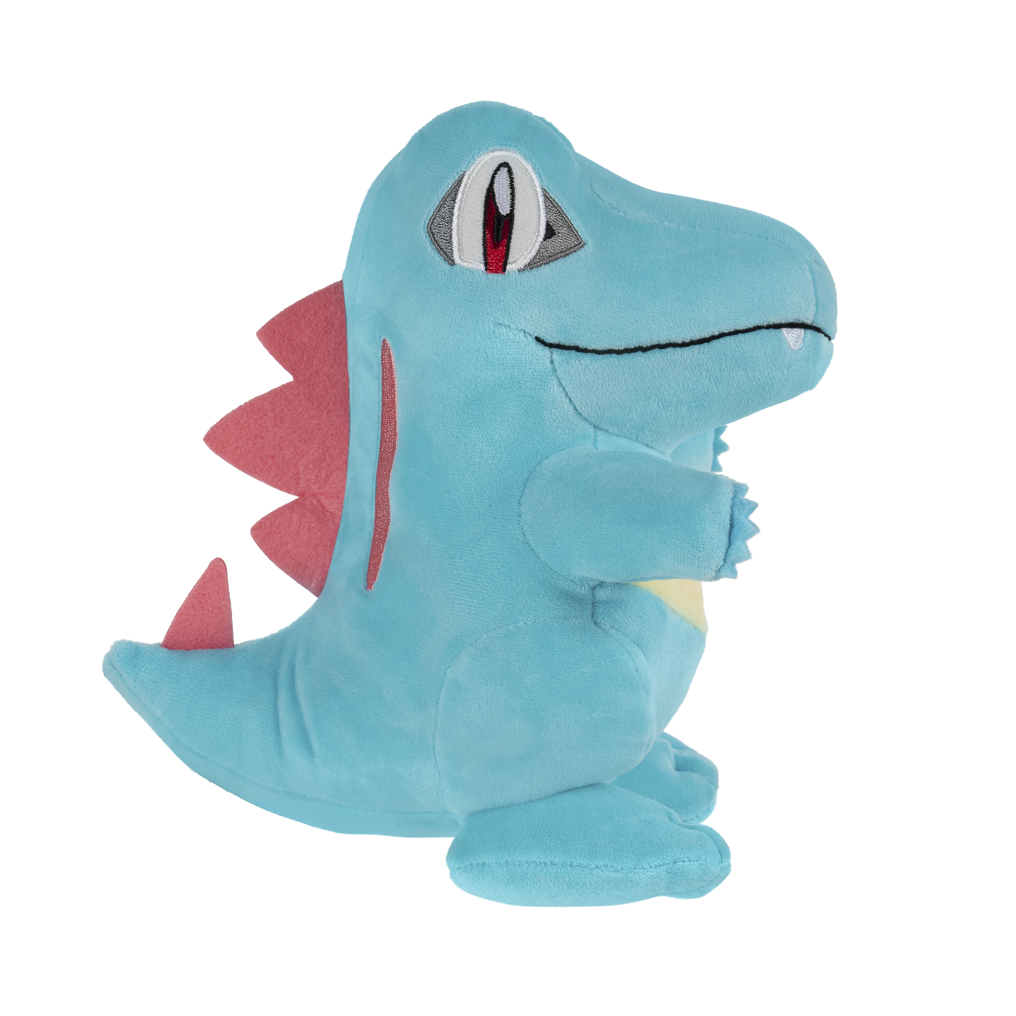 Ein blaues Totodile-Plüschtier. Es hat rote Stacheln, einen gelben Bauch und ein lächelndes Gesicht. Auf weißem Hintergrund.