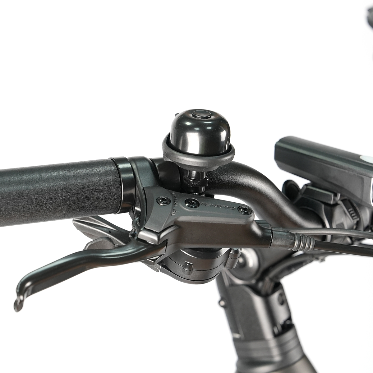 Zbliżenie kierownicy roweru z dzwonkiem i dźwignią hamulca. Kierownica jest czarna, z dzwonkiem i dźwignią.