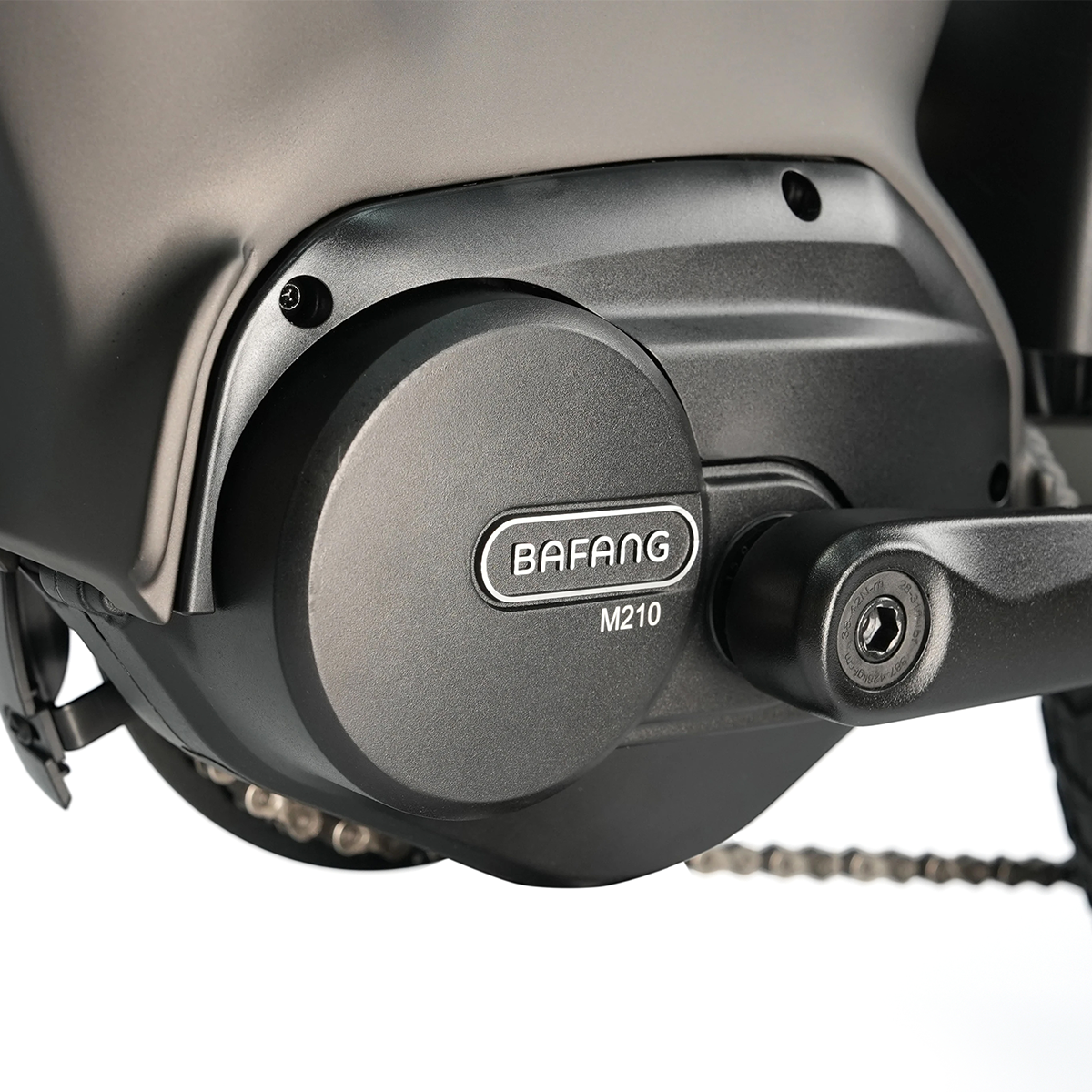 Zbliżenie czarnego silnika Bafang M210 do roweru elektrycznego. Silnik jest zamontowany na szarej ramie. Widoczny jest łańcuch i korba.