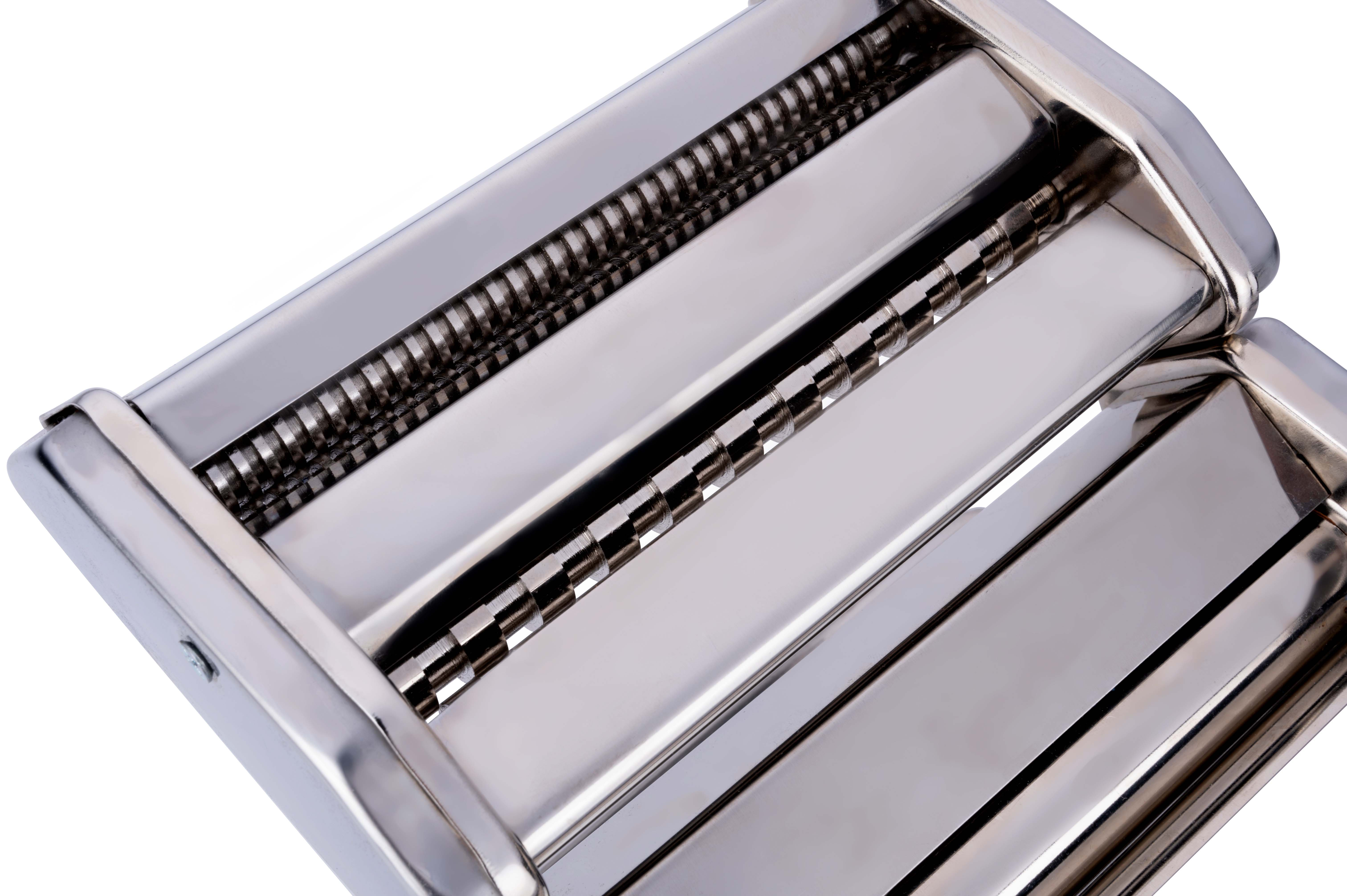 A close-up shot of a stainless steel pasta maker, with rollers and cutting blades visible against a white backdrop.