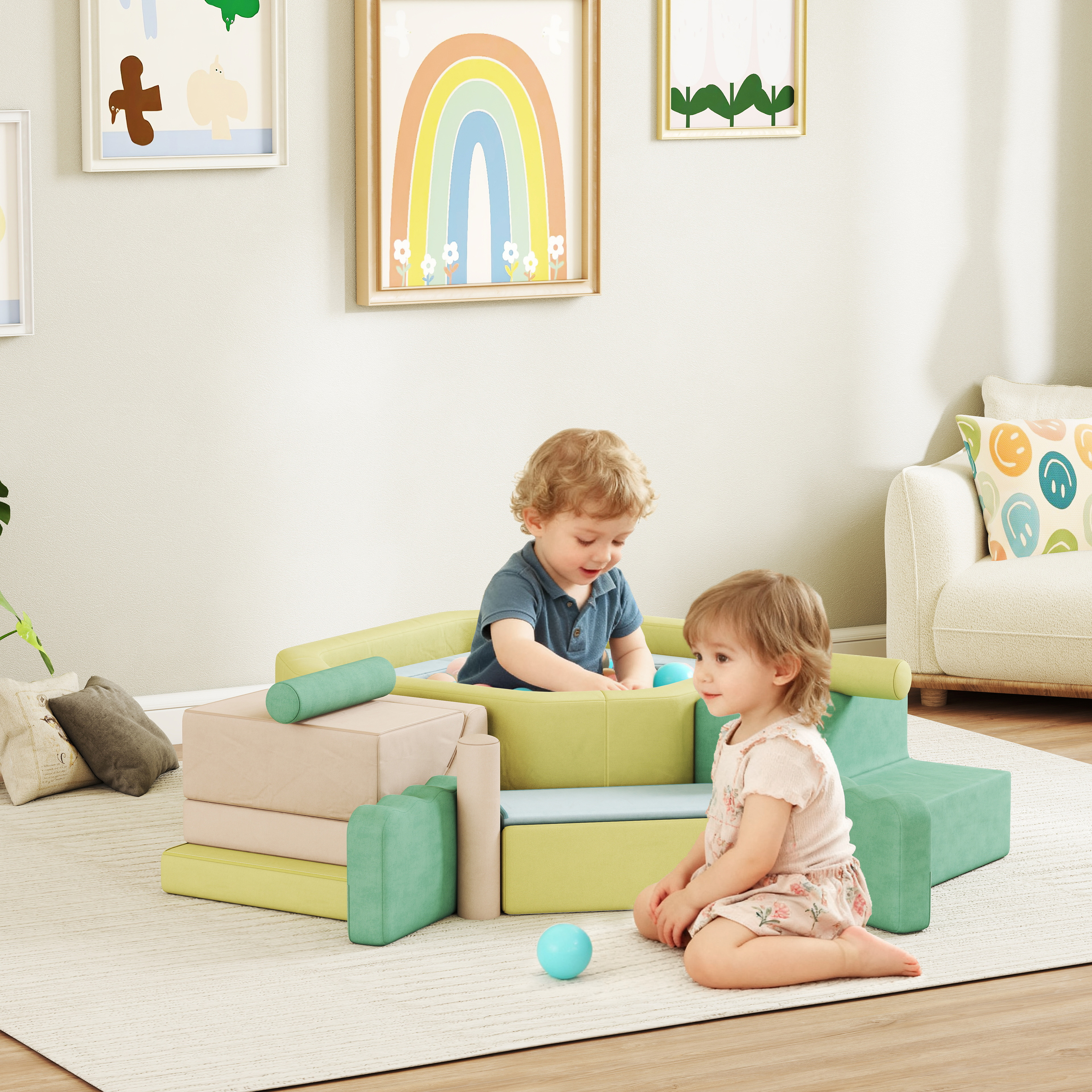 Due bambini giocano con una palla blu vicino a un divano gioco verde e beige. Arte murale visibile sullo sfondo.