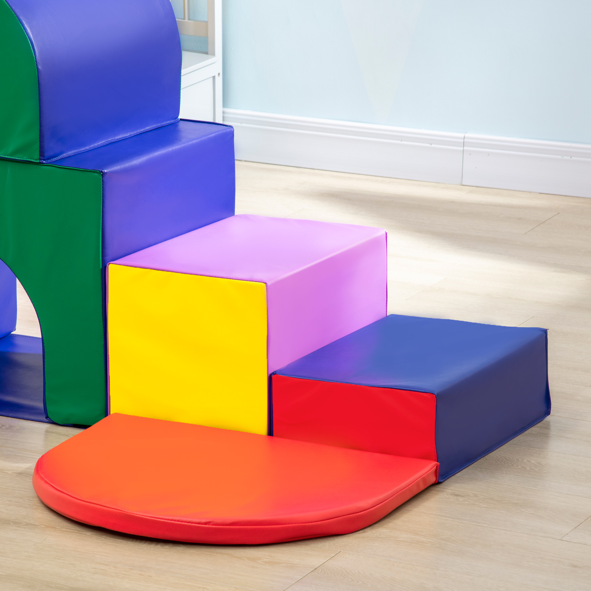 Un set da gioco in schiuma colorato. Ha blocchi blu, verdi, gialli, rosa e rossi, disposti a gradini.