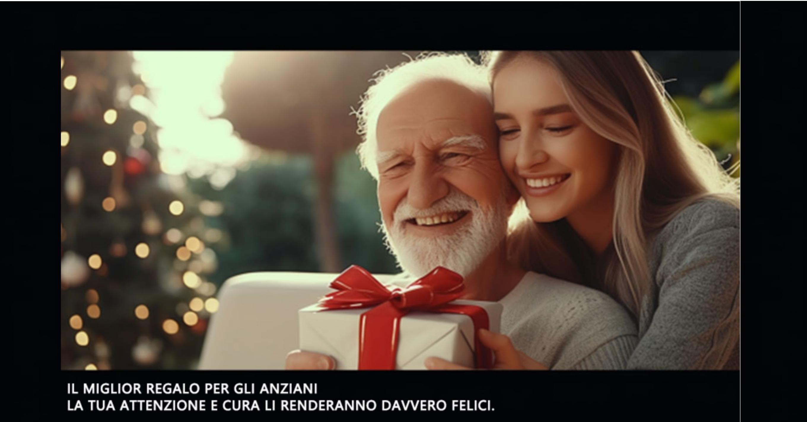 Un uomo anziano e una giovane donna sorridono, tenendo un regalo con un fiocco rosso. Albero di Natale sullo sfondo.