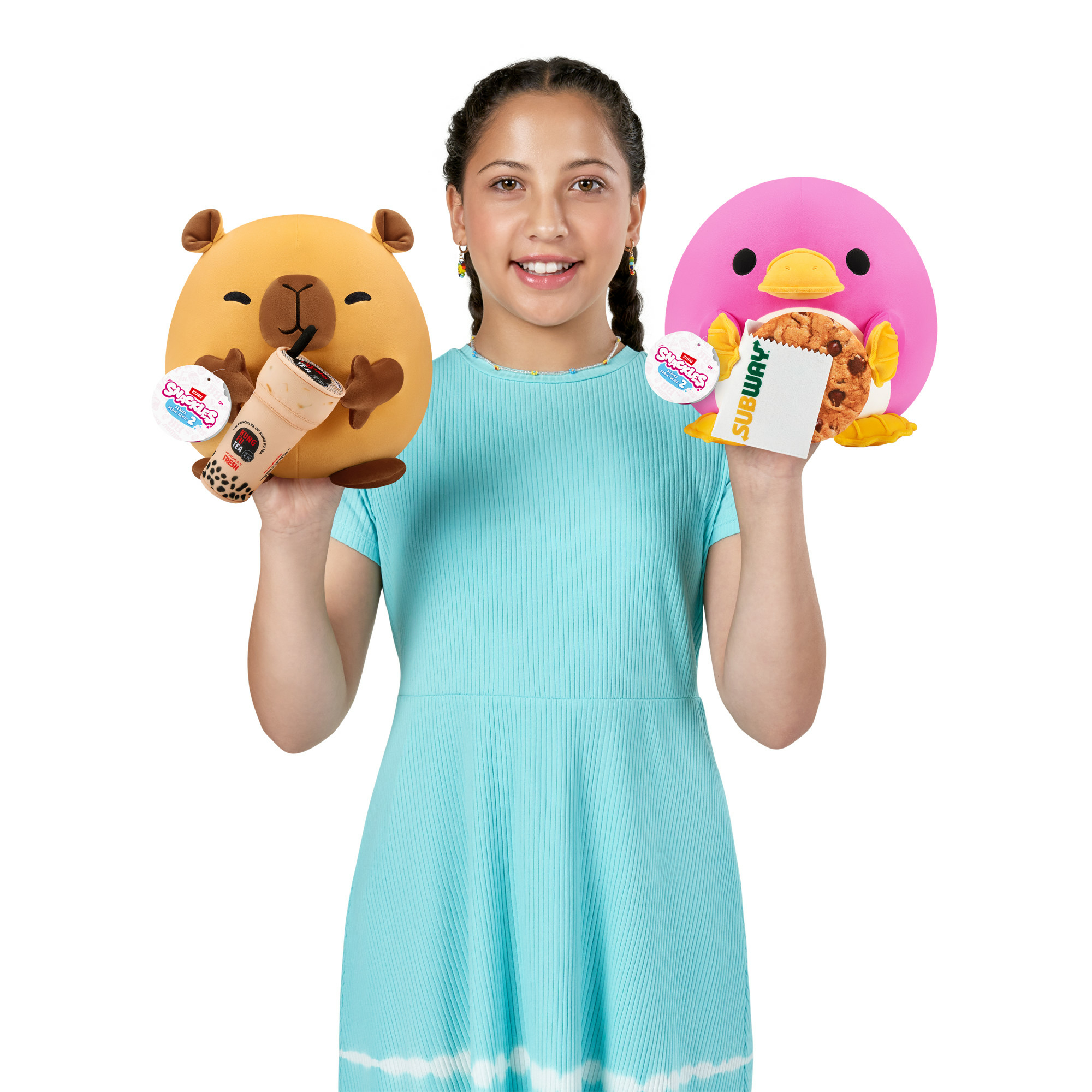 Ein Mädchen in einem blauen Kleid hält einen Bärenplüsch mit Boba-Tee und einen Pinguinplüsch mit einem Keks.