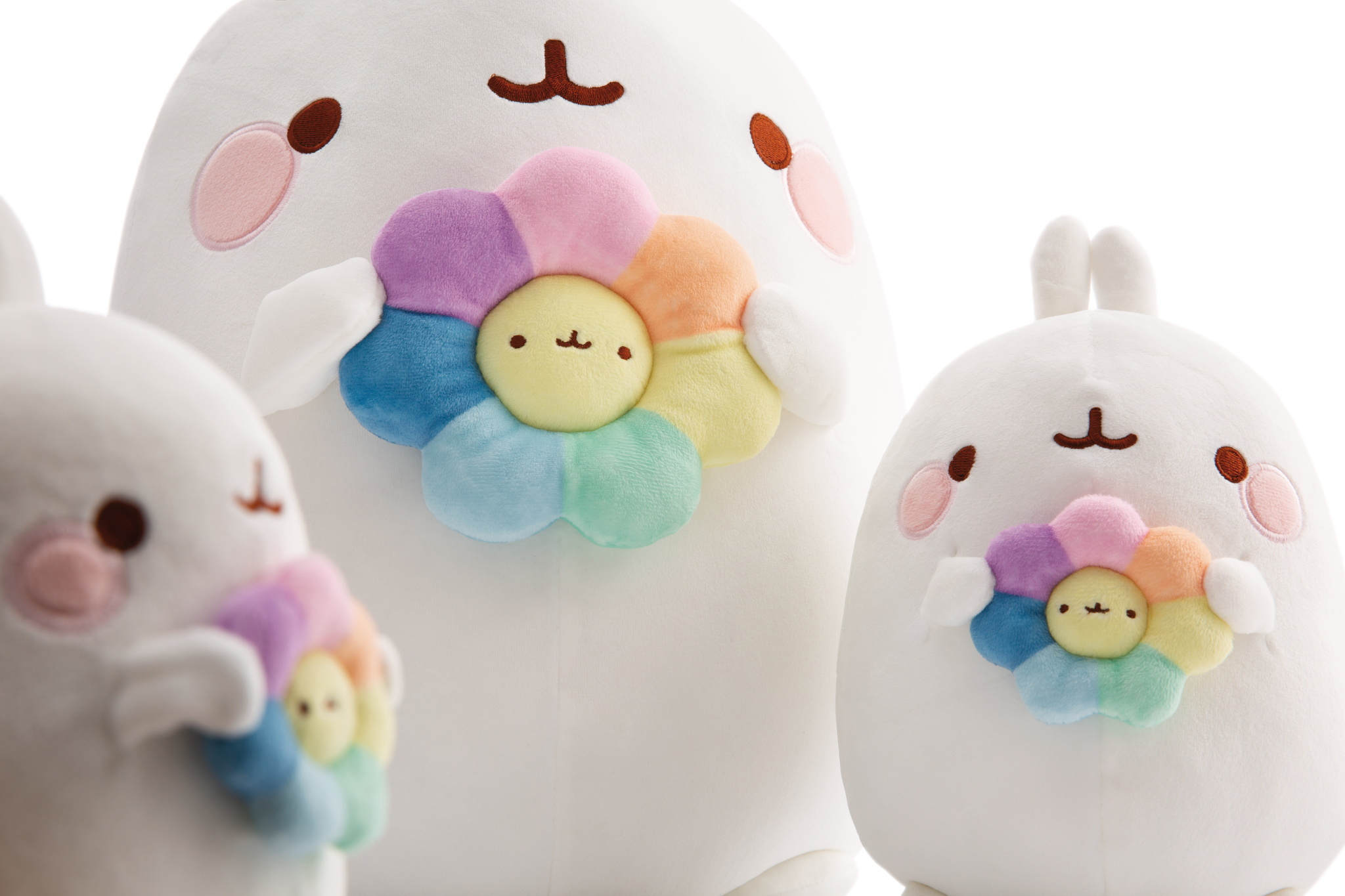 Tre peluche bianchi con decorazioni floreali, ognuno con guance rosa e dettagli marroni.