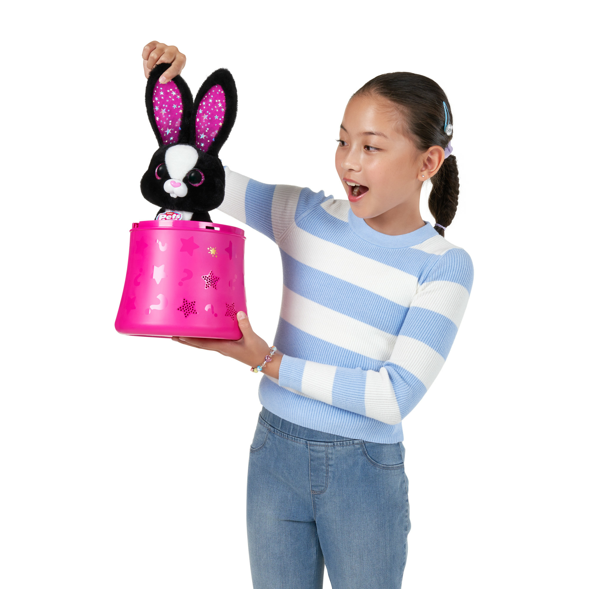 Ein Mädchen hält einen rosa Zylinder mit einem schwarzen Spielzeug-Hasen. Der Hase hat rosafarbene Ohren mit Sternen.