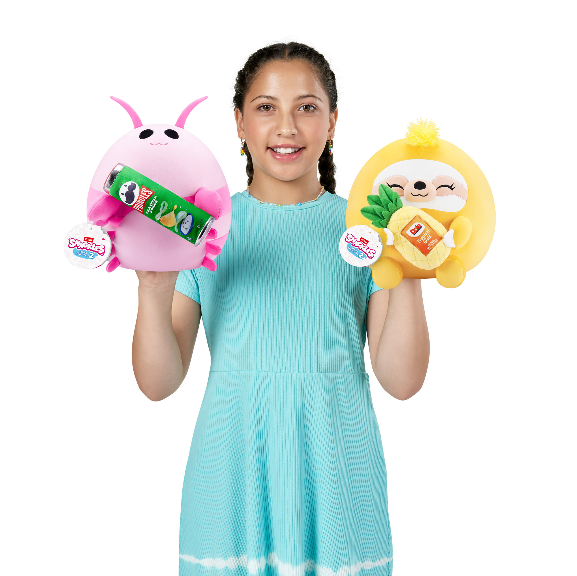 Ein Mädchen hält ein rosa Käfer-Spielzeug mit Pringles und ein gelbes Faultier-Spielzeug mit einer Ananas und lächelt in die Kamera.