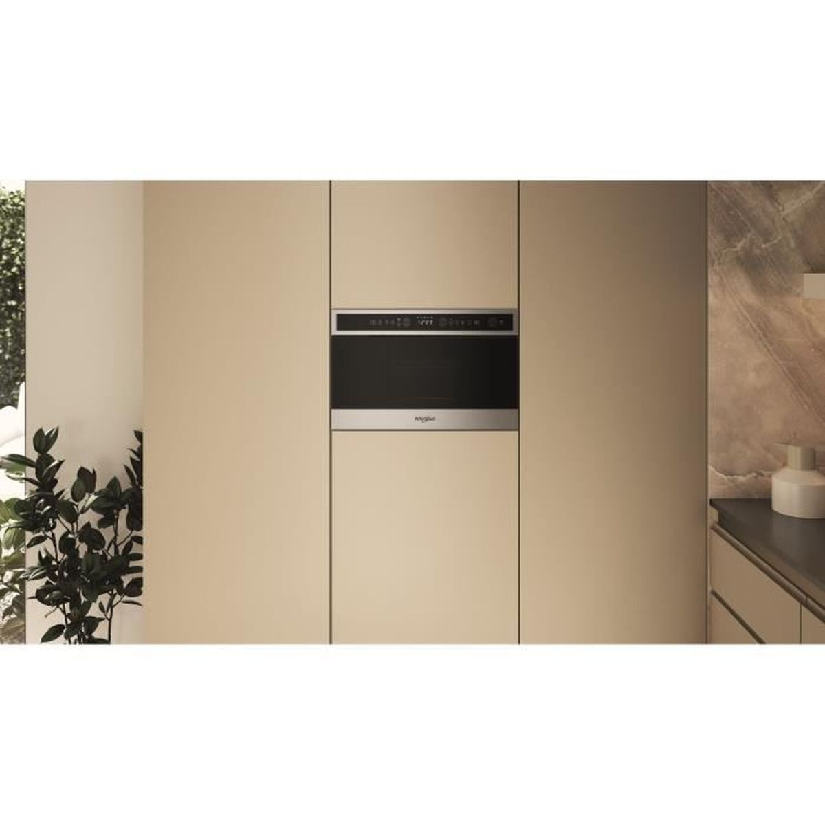 Horno empotrado en una cocina moderna. Los armarios beige rodean el horno. Una planta visible a la izquierda. Encimera a la derecha.
