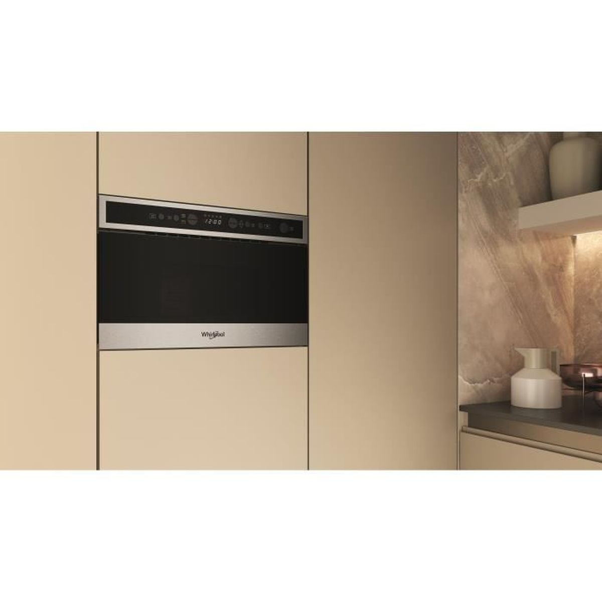 Horno microondas empotrado. Armarios beige rodean el horno negro. A la derecha, una estantería con una jarra blanca.