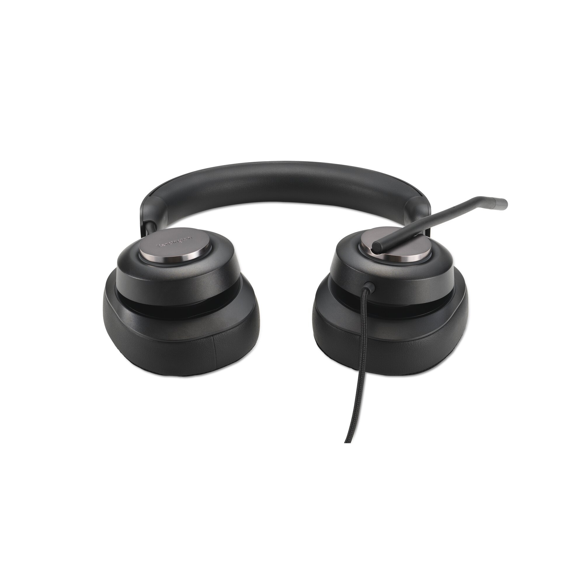 Cuffie nere con microfono su superficie bianca. L'auricolare destro ha un microfono collegato.