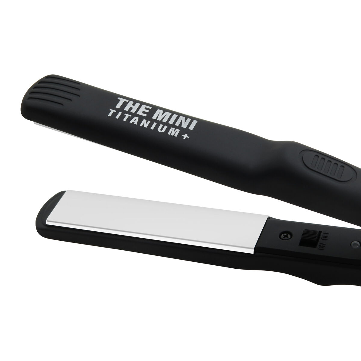 Se muestra una plancha de pelo negra, "THE MINI TITANIUM+". Tiene una placa plateada y un interruptor de encendido/apagado. El fondo es blanco.