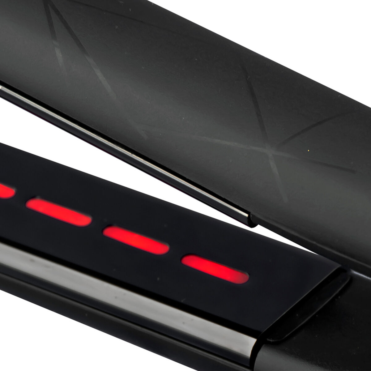 Primer plano de una plancha de pelo negra con luces rojas. La parte superior está abierta, mostrando una superficie estampada.
