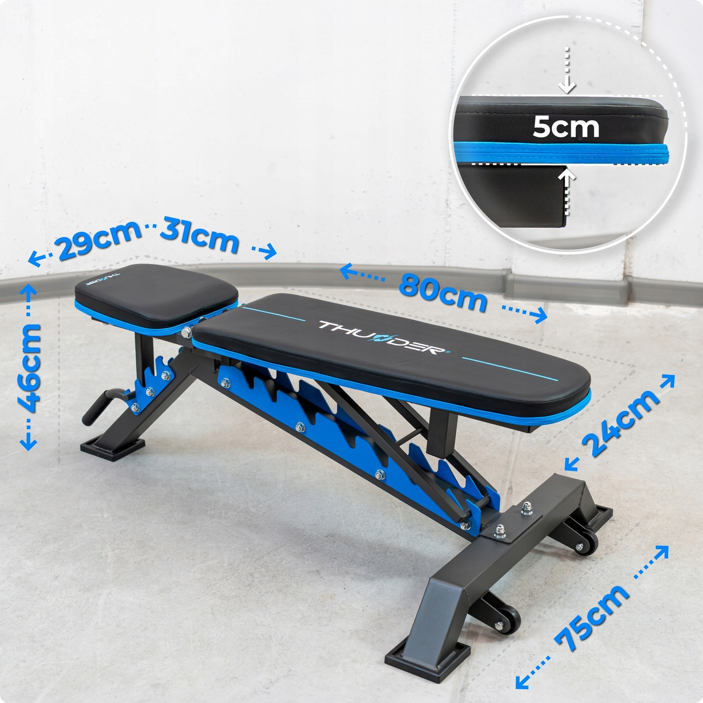 Regulowana ławka do ćwiczeń. Ma czarne siedzisko i oparcie z niebieskimi akcentami. Wymiary wskazane strzałkami i liczbami.