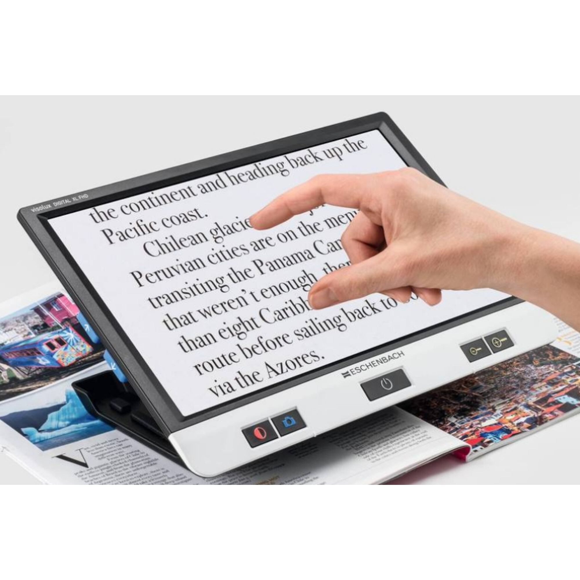 Eine Hand zeigt auf Text auf einem Bildschirm. Der Bildschirm liegt auf offenen Zeitschriften. Das Gerät ist eine digitale Lupe.