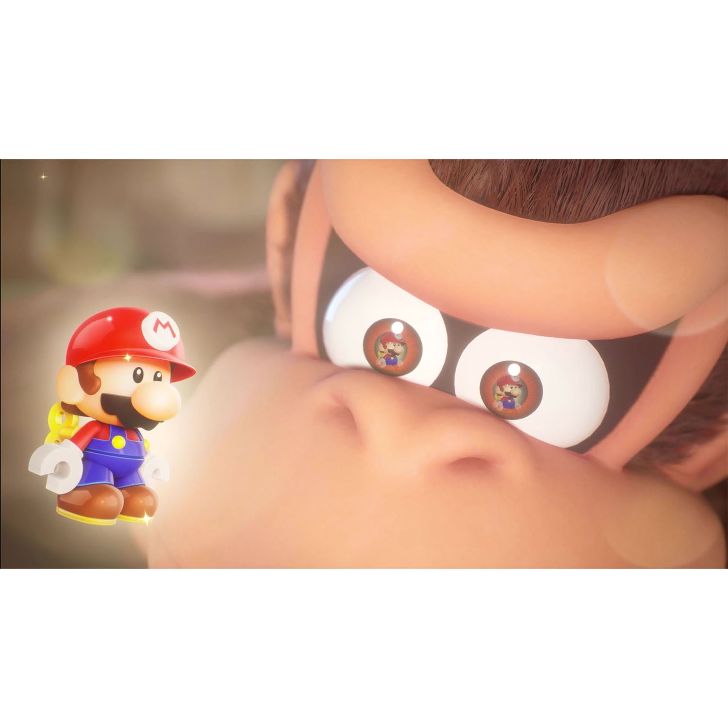 Un juguete de Mario se encuentra frente a un primer plano de la cara de Donkey Kong. Mario tiene un sombrero rojo. Los ojos de Donkey Kong reflejan a Mario.