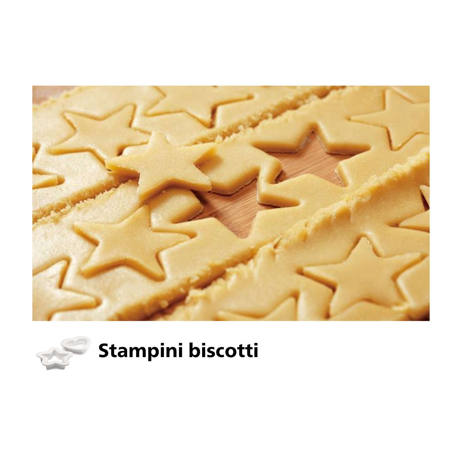 Close-up of star-shaped cookies cut from dough. Two cookie cutters next to the image. Background is wooden.