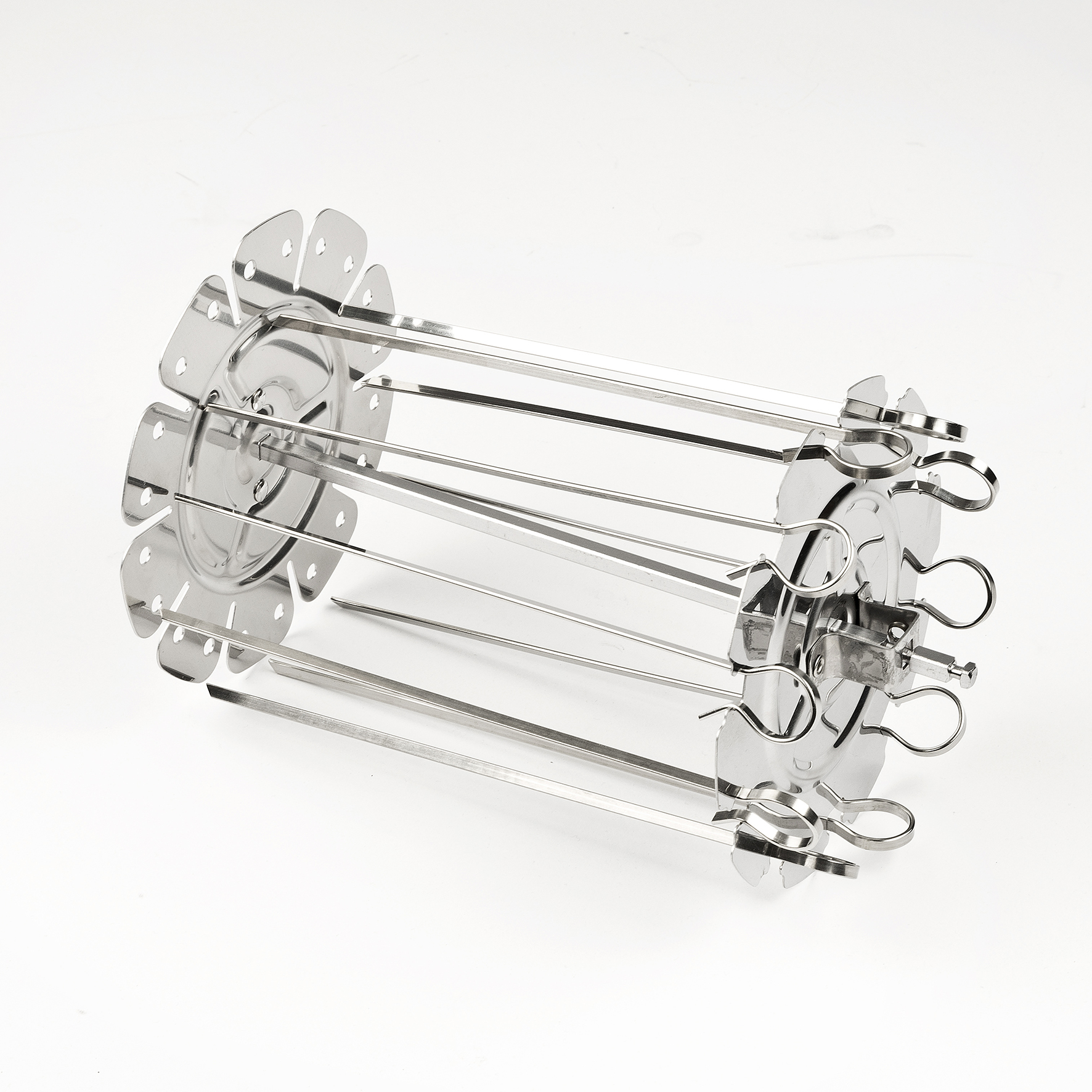 Grill obrotowy ze stali nierdzewnej. Ma cylindryczny kształt z szaszłykami i elementami w kształcie kwiatów na białym tle.