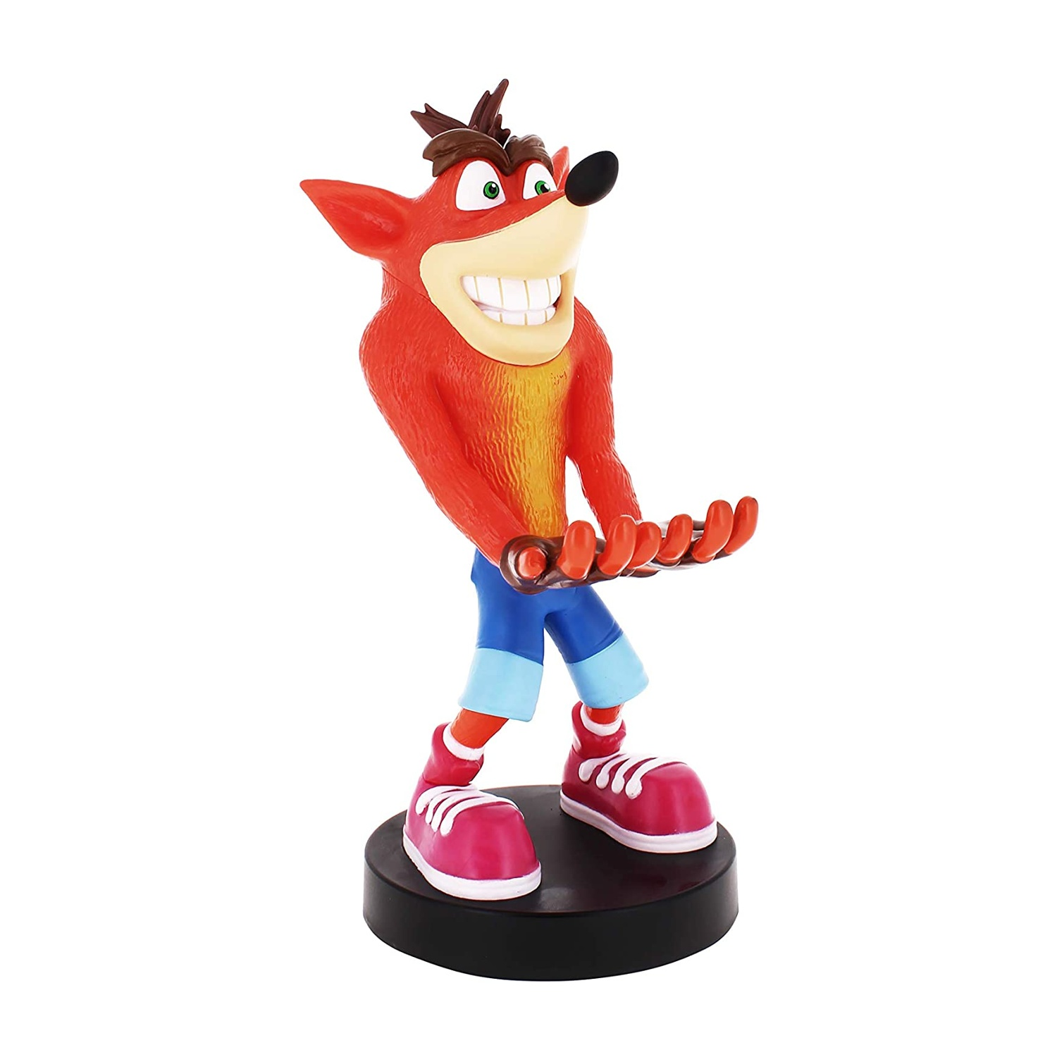 Una statuetta di Crash Bandicoot, pelliccia arancione, pantaloncini blu, scarpe rosse, base nera, sfondo bianco. Sorride.