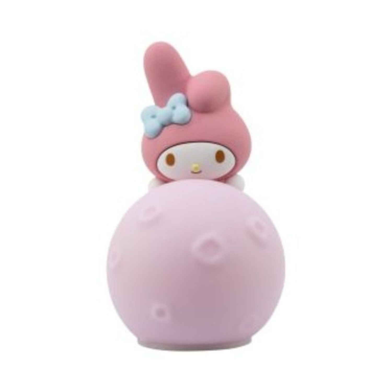 Una figura rosa di My Melody è seduta sopra una sfera rosa. My Melody ha una testa rosa, un fiocco blu e una faccia bianca.