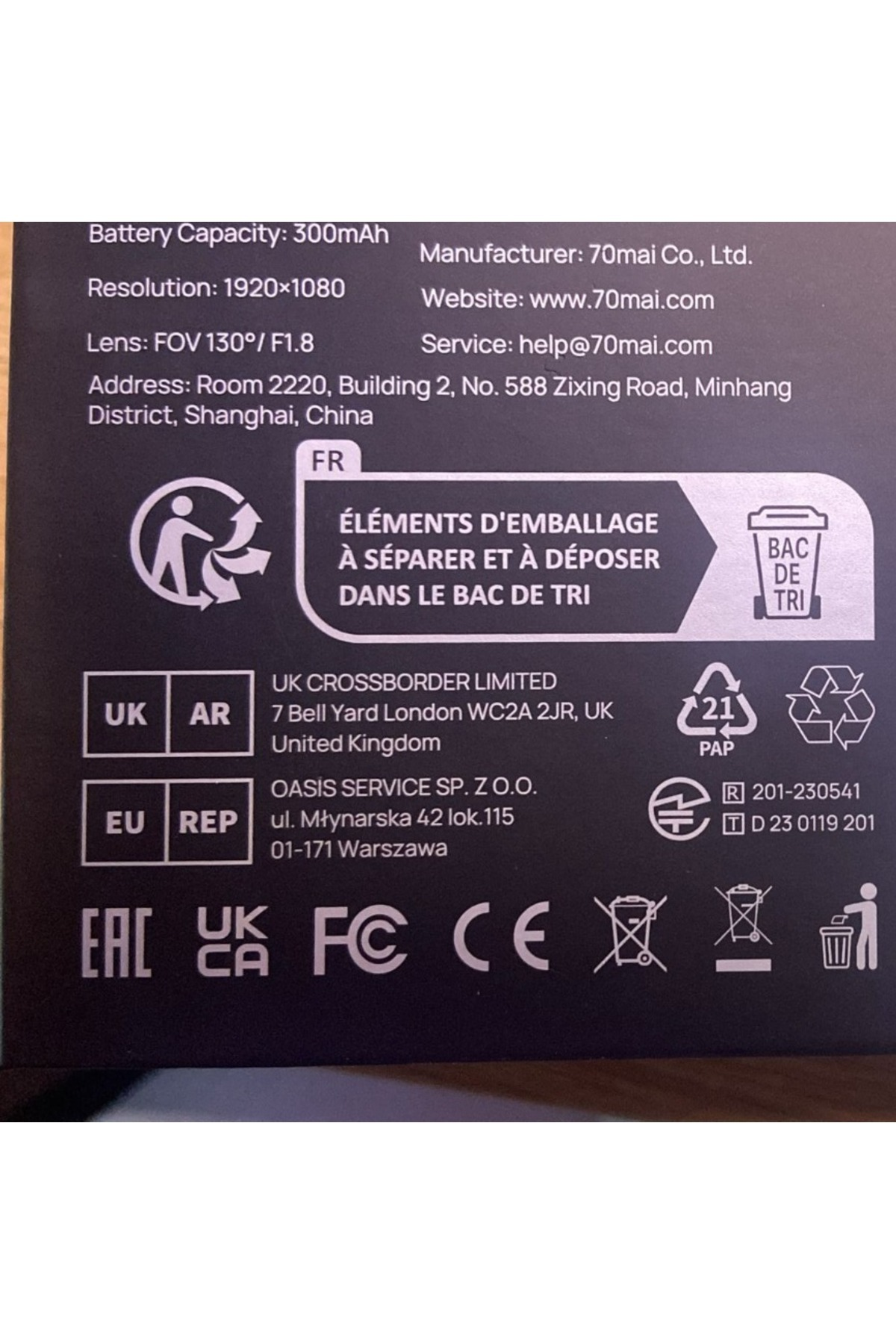 Etichetta nera del prodotto con testo: capacità della batteria, risoluzione, obiettivo, produttore, sito Web, indirizzo e simboli di riciclaggio.