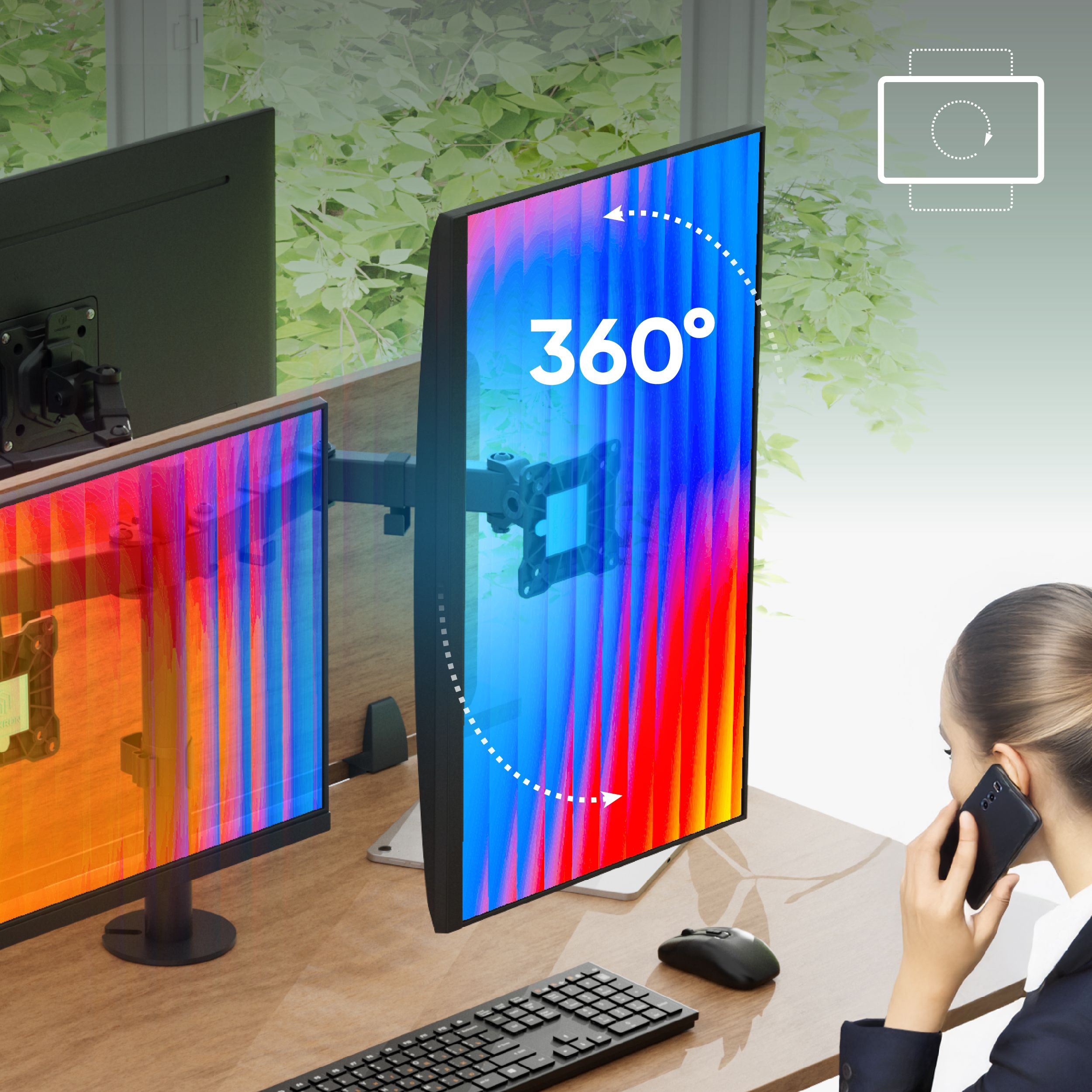 Una donna al telefono vicino a una scrivania con due monitor. Un monitor mostra linee colorate e l'altro è nero.