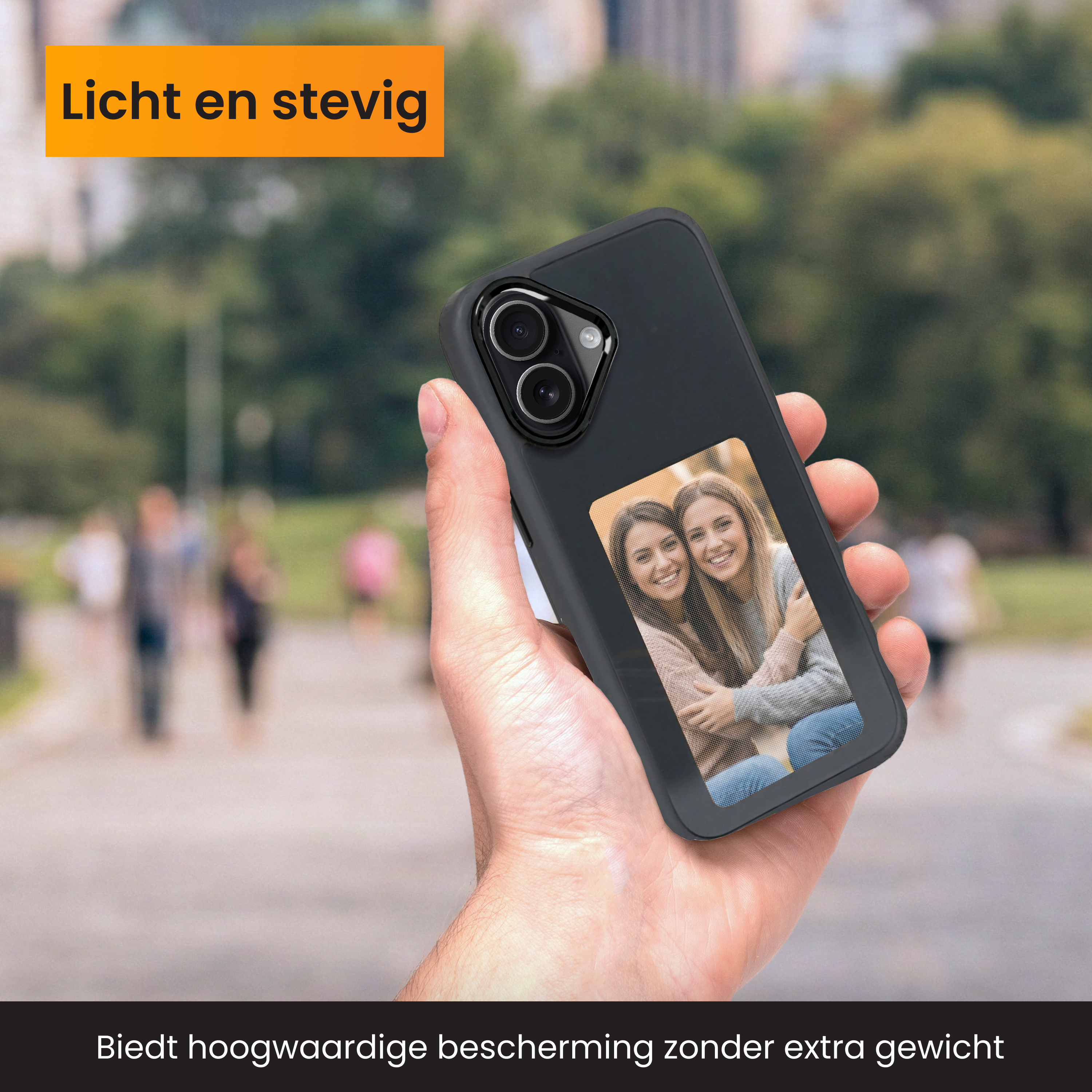 Hand hält ein Telefon mit einem Bild von zwei Frauen. Der Hintergrund ist eine verschwommene Außenszene.