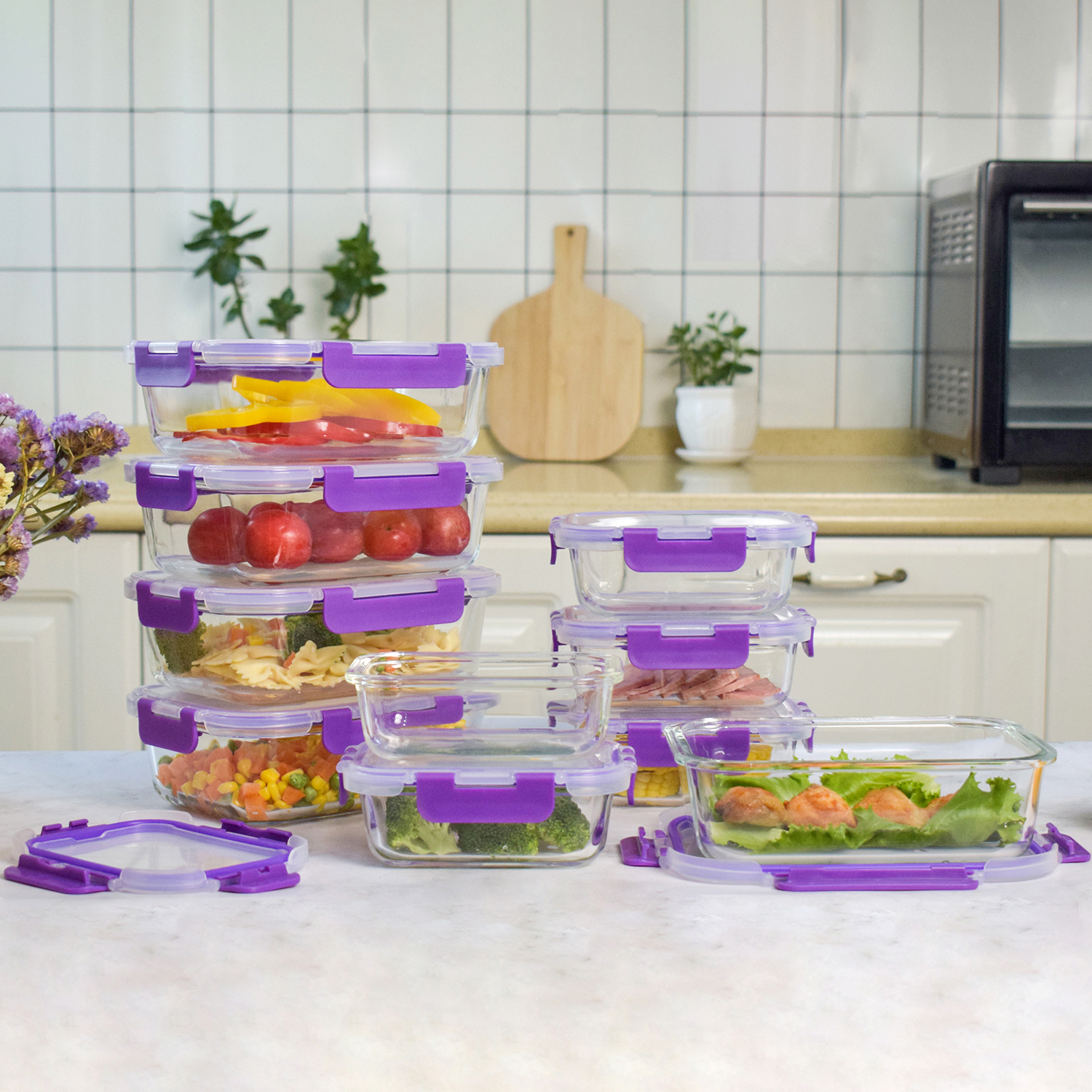 Contenedores de comida de vidrio con tapas moradas, llenos de verduras y frutas. Ambiente de cocina con horno al fondo.