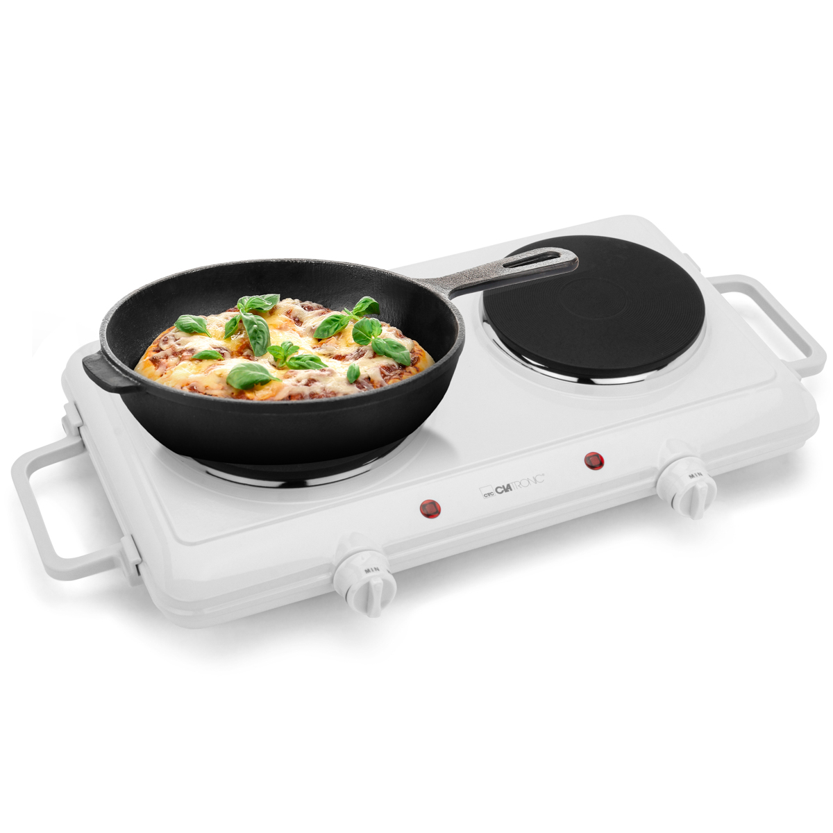 Pizza w czarnej patelni stoi na białej przenośnej kuchence. Kuchenka ma dwa palniki, pokrętła i czerwone światła.
