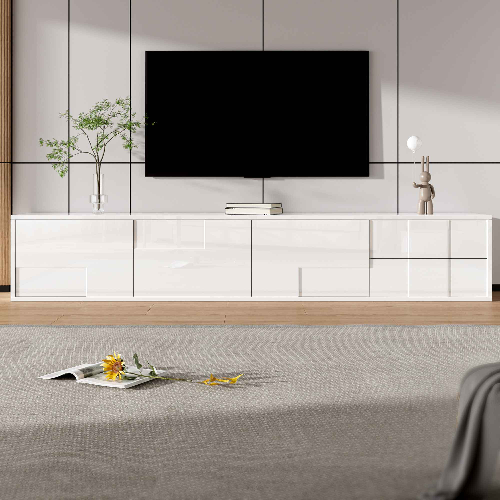 Ein modernes Wohnzimmer mit Fernseher über einem weißen Schrank. Auf dem Teppich liegen eine Blume und ein Buch.