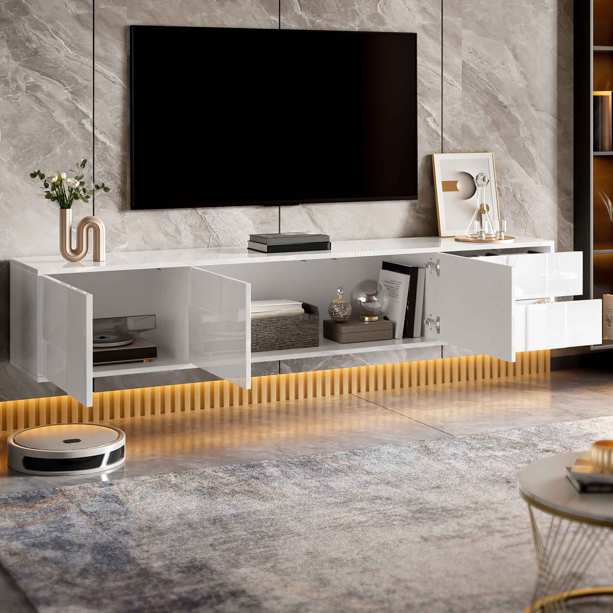 Ein modernes Wohnzimmer mit großem Fernseher über einem weißen Schrank. Ein Roboterstaubsauger steht auf dem Boden.