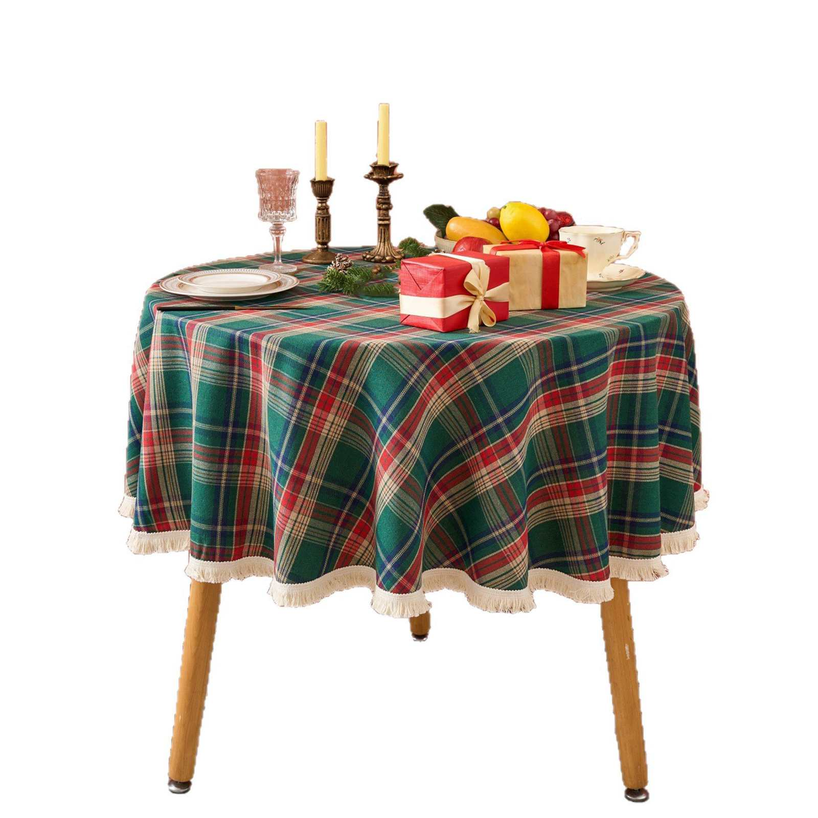 Runder Tisch mit grün karierter Tischdecke. Geschenke, Kerzen, Früchte und eine Teetasse auf dem Tisch, mit Holzbeinen.