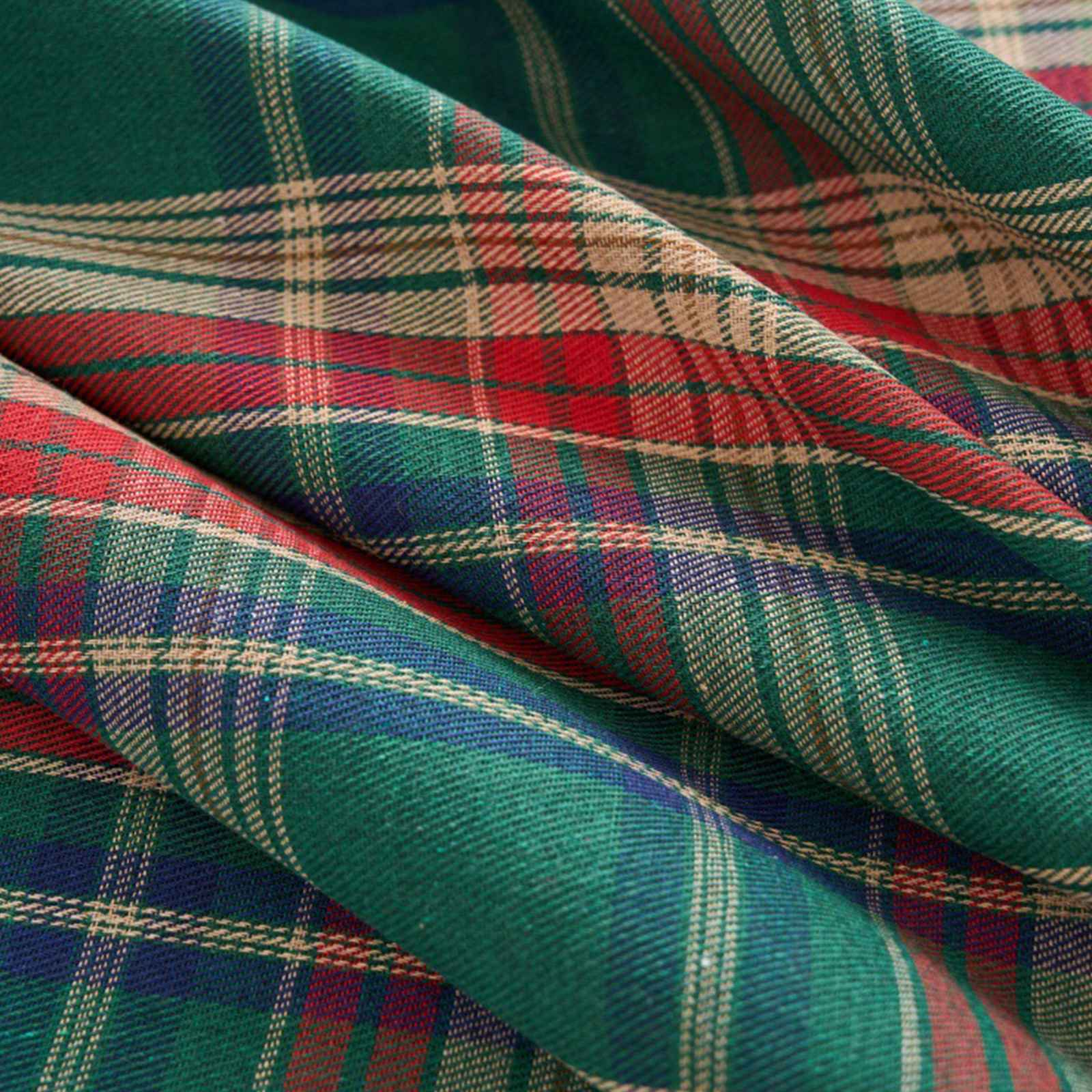 Nahaufnahme eines karierten Stoffes mit grünen, roten, blauen und beigefarbenen Linien.