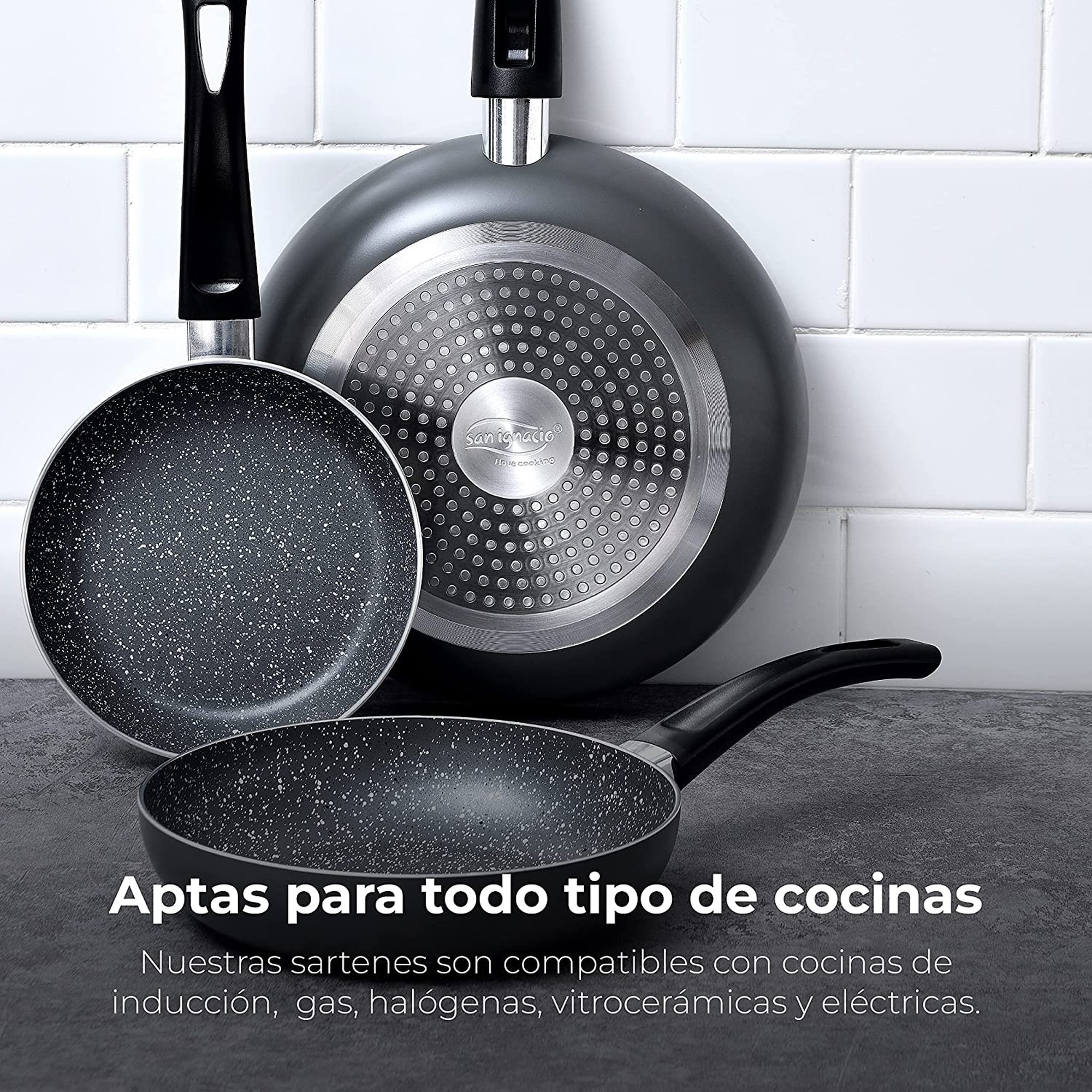 Tres sartenes antiadherentes. La sartén inferior tiene texto en español. Fondo de azulejos blancos.