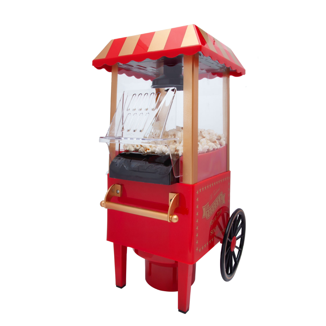Una máquina de palomitas roja y dorada. Tiene un techo a rayas, lados transparentes y una rueda negra. La máquina está llena de palomitas.