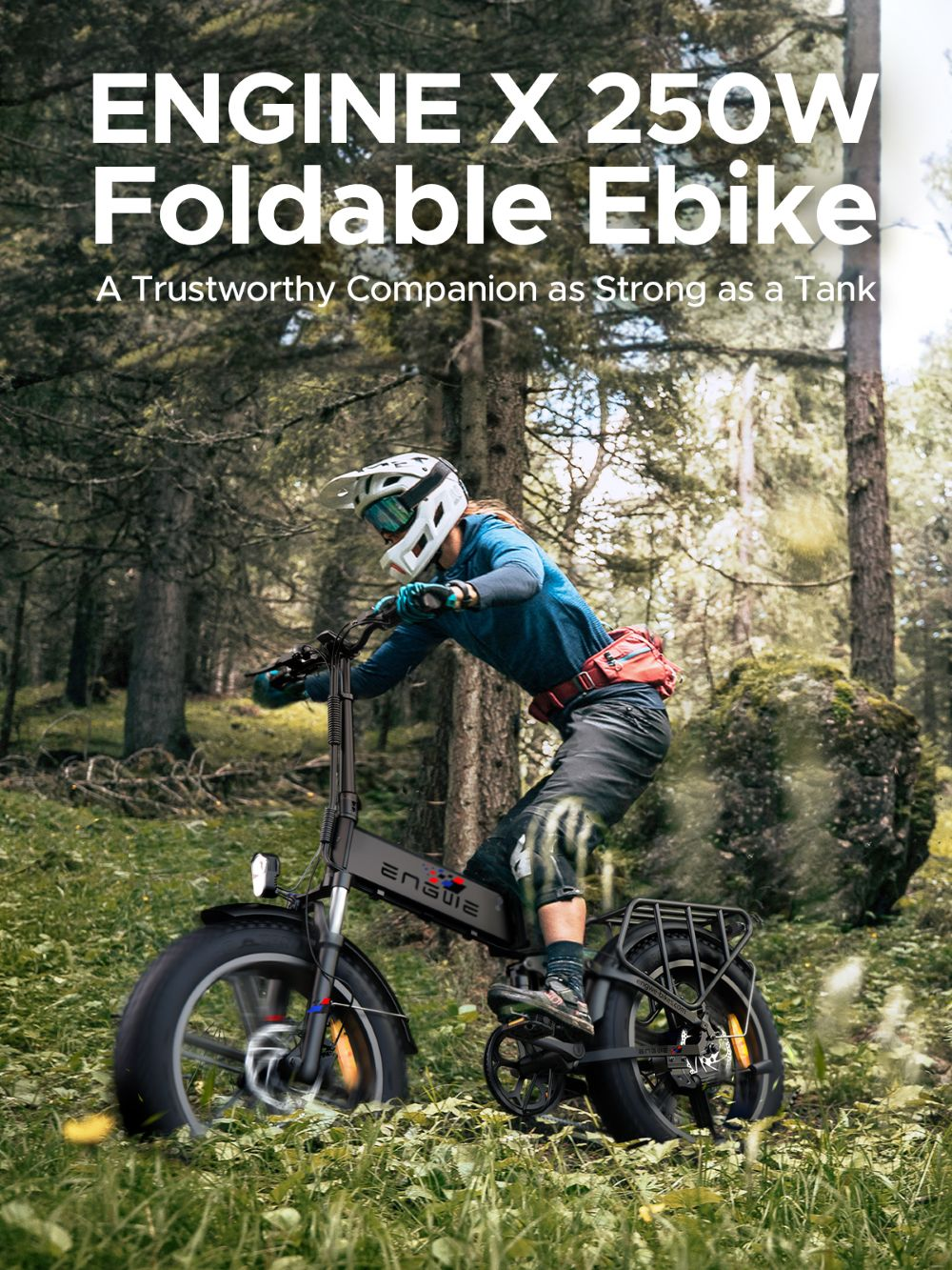 Una persona monta una e-bike Engine X negra en un bosque. La persona lleva casco y camisa azul. El fondo son árboles.