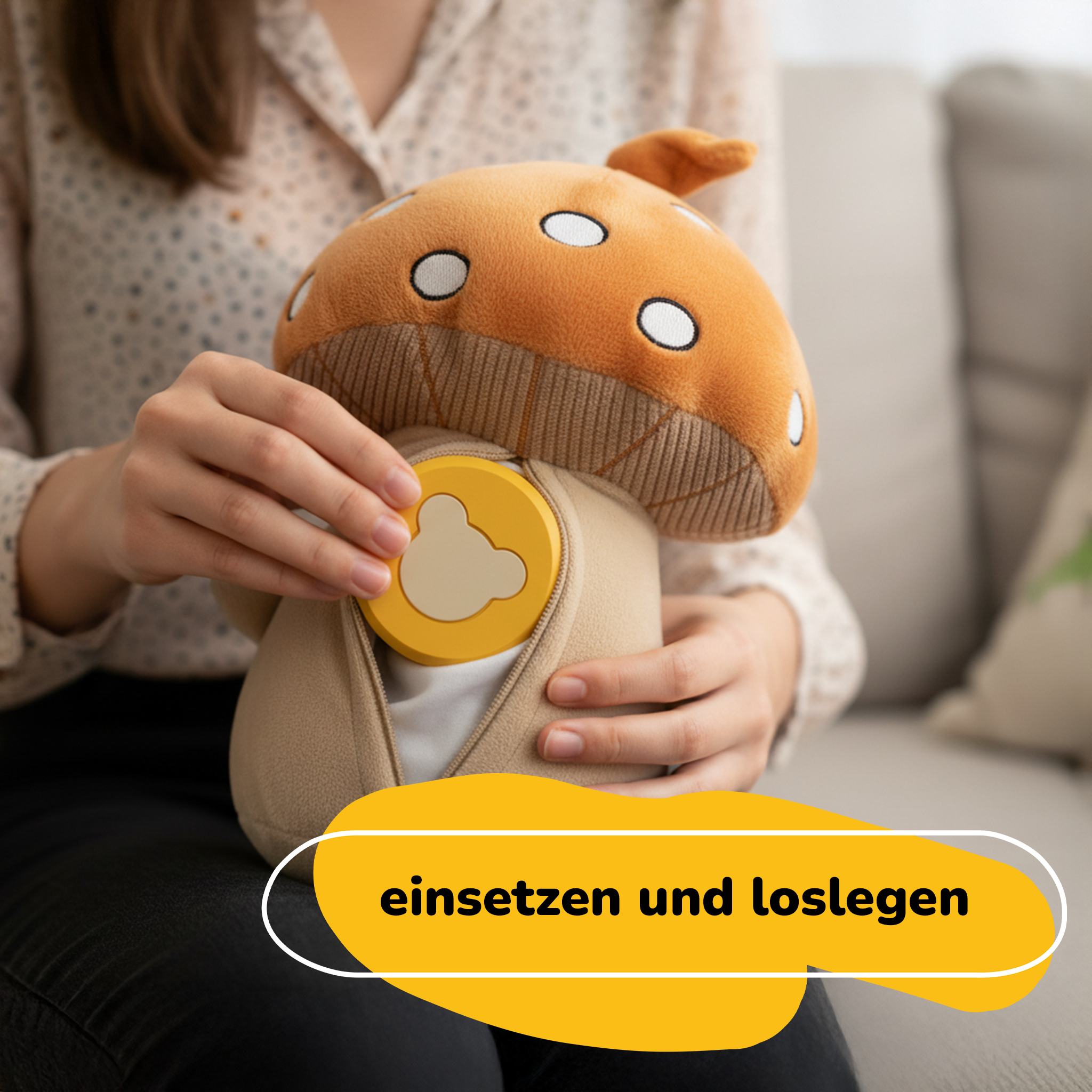 Eine Person hält ein pilzförmiges Spielzeug. Es hat eine Öffnung, in die eine gelbe Scheibe eingesetzt wird, mit deutschem Text.