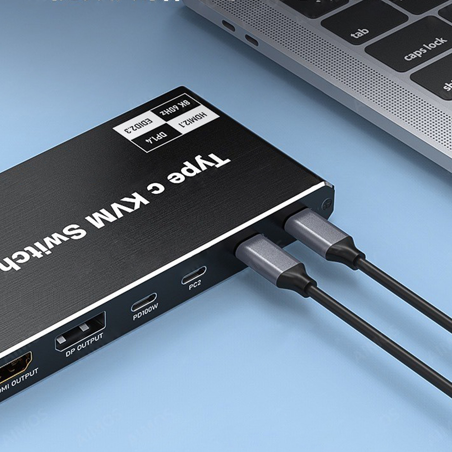 Ein schwarzer Typ-C-KVM-Switch ist über zwei Kabel mit einem Laptop verbunden. Textlabels umfassen HDMI, DP und Leistungsdetails.