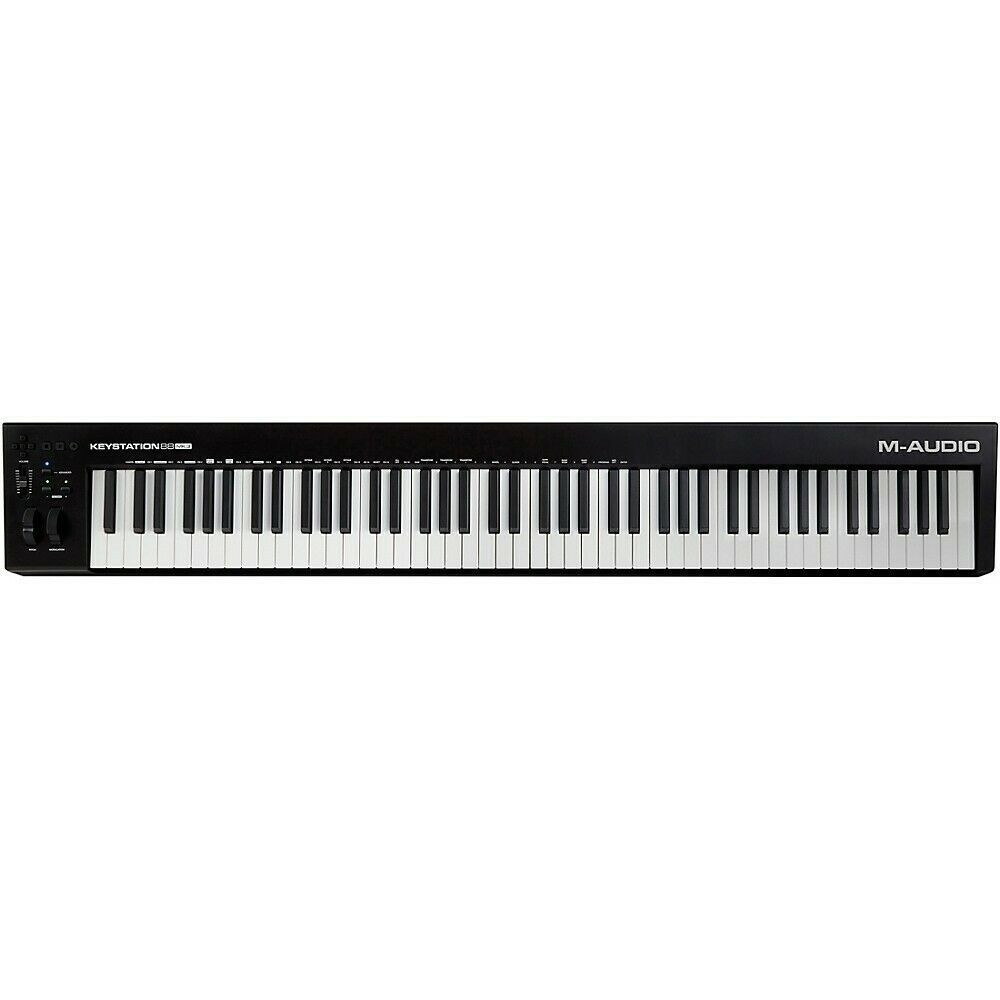 Czarna klawiatura M-Audio Keystation 88 z białymi i czarnymi klawiszami. Pokrętła i przyciski po lewej. Logo M-Audio po prawej.