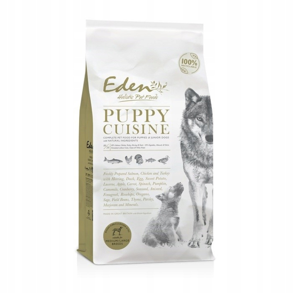 Bolsa de comida para perros. Presenta un cachorro y un lobo. El texto dice 'Puppy Cuisine' y enumera ingredientes como salmón y pollo.