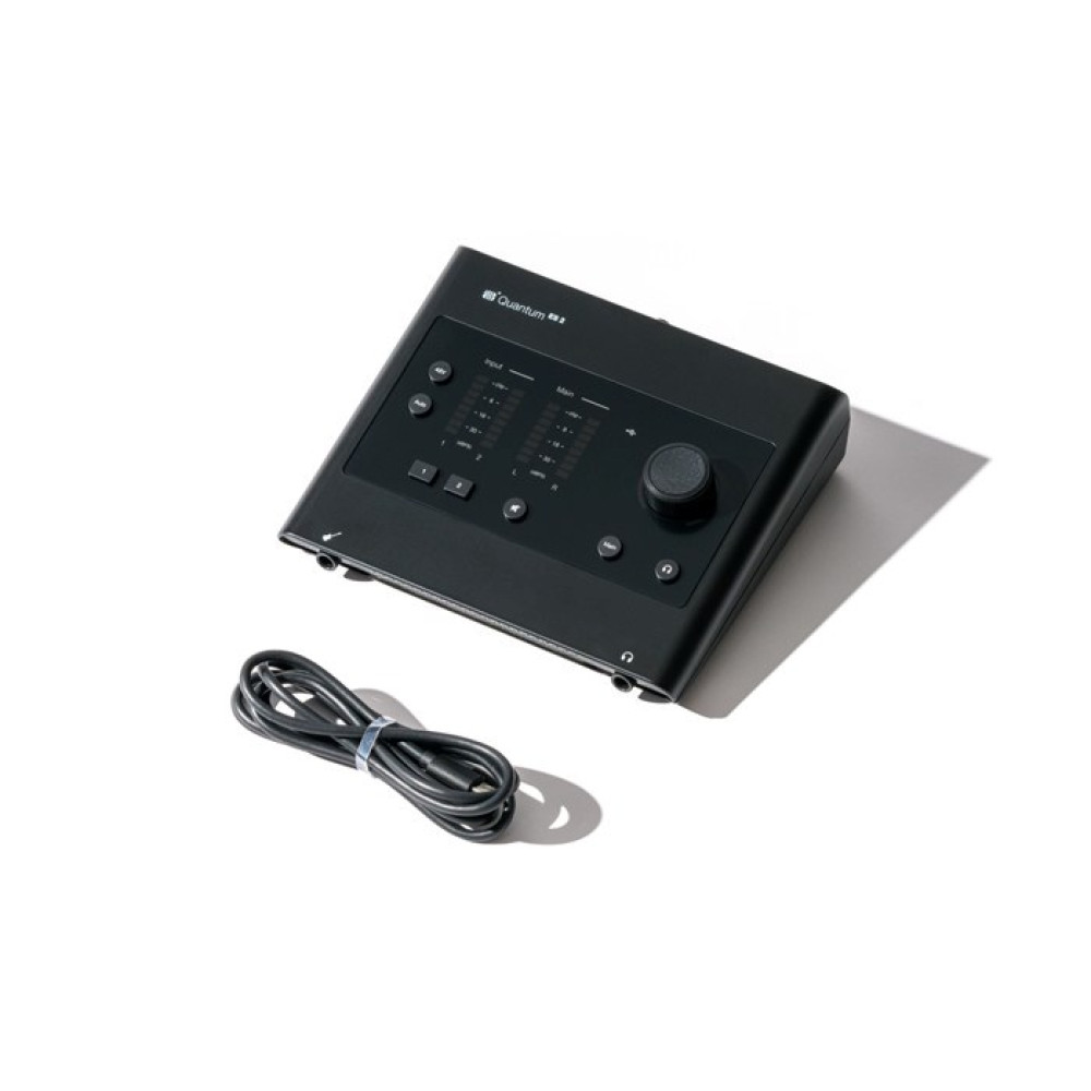 Czarny interfejs audio z pokrętłami i przyciskami, obok kabel. Białe tło.