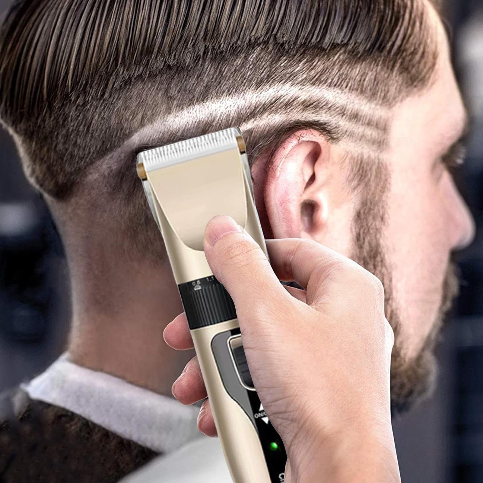 Eine Person benutzt einen goldenen Haarschneider an den gemusterten Haaren einer anderen Person. Der Clipper wird nahe am Kopf gehalten.