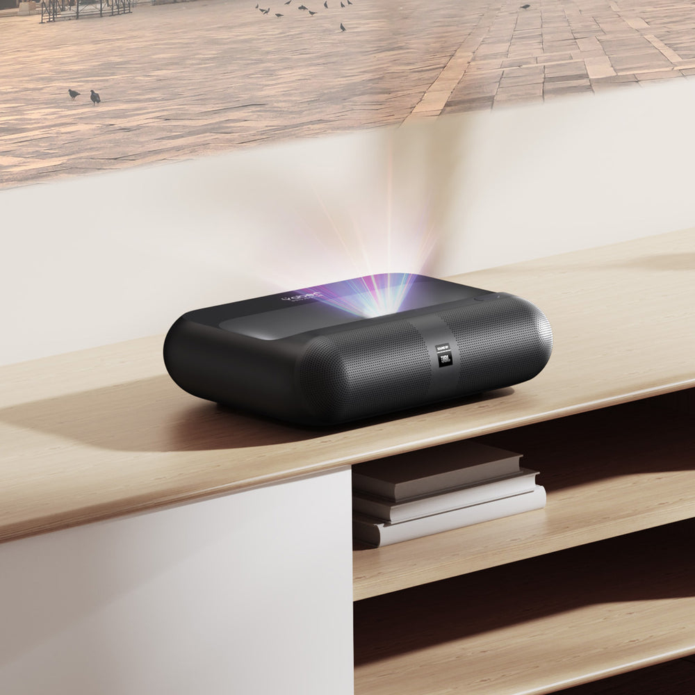 Czarny projektor na drewnianej powierzchni. Promienie światła. Tło przedstawia kamienny plac z latającymi ptakami.