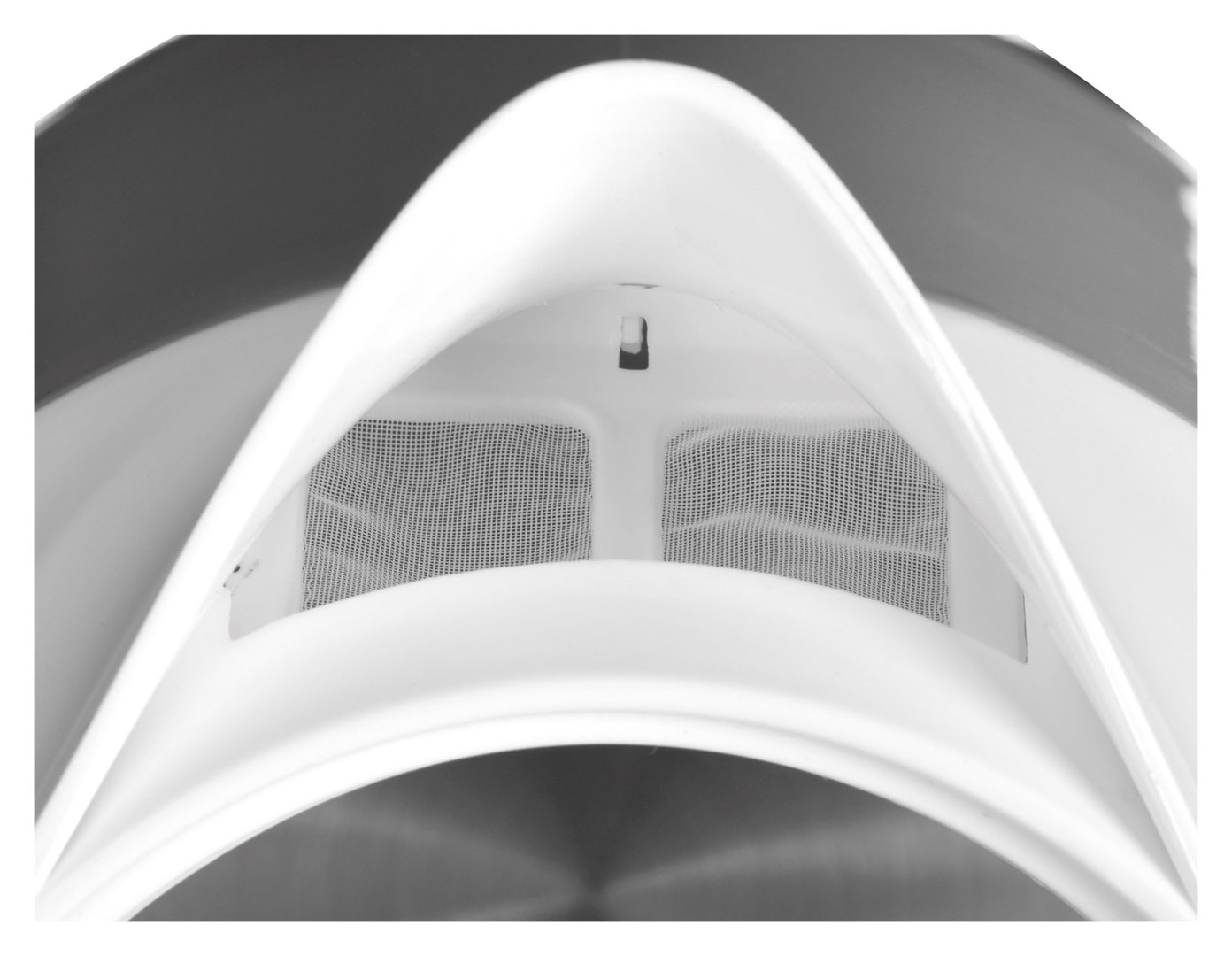Primo piano dell'interno di un bollitore bianco. È visibile una rete, racchiusa da plastica bianca. Lo sfondo è una sfumatura di grigio.