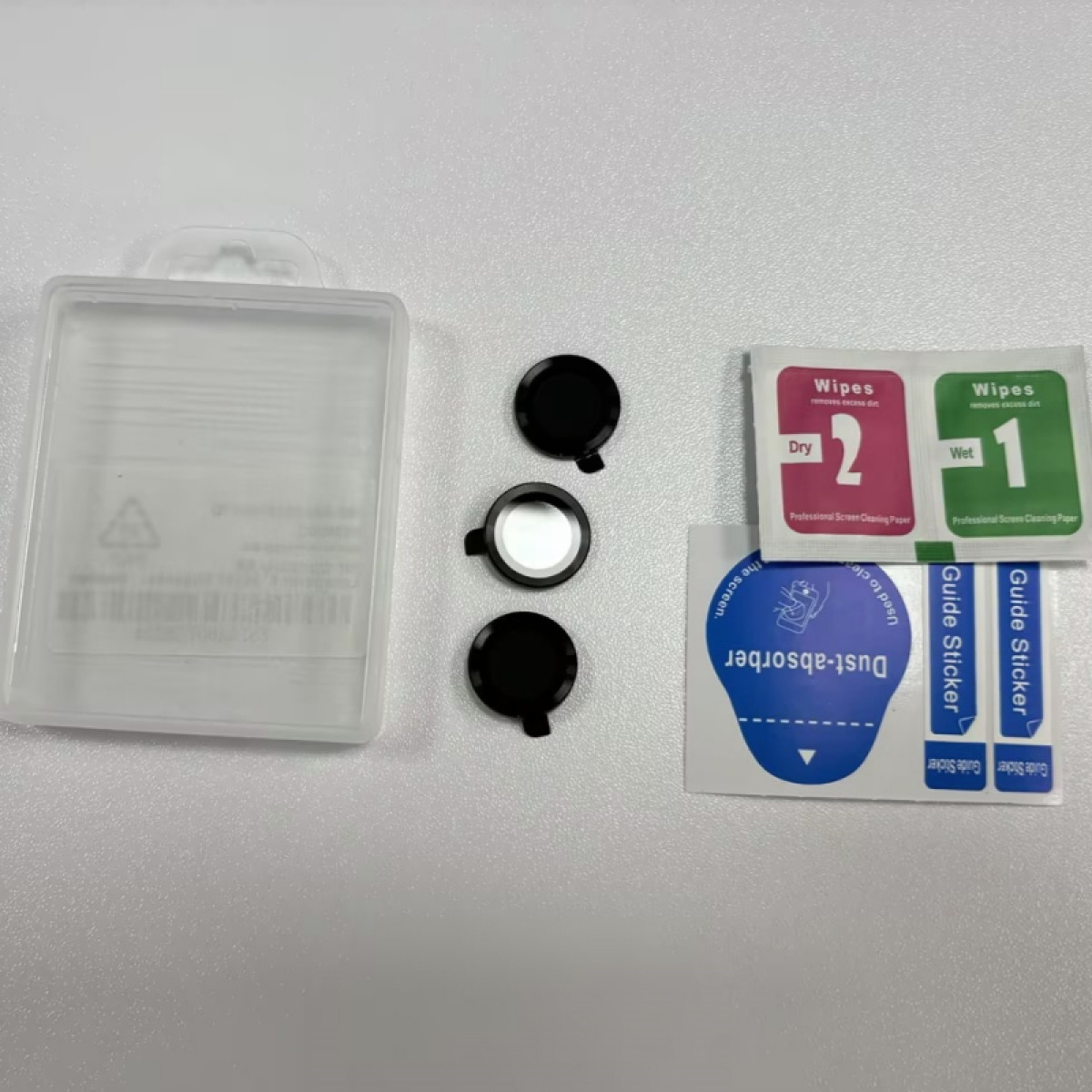 Zestaw do ochrony ekranu telefonu: ochraniacze ekranu, chusteczki i naklejki ułożone na białej powierzchni.