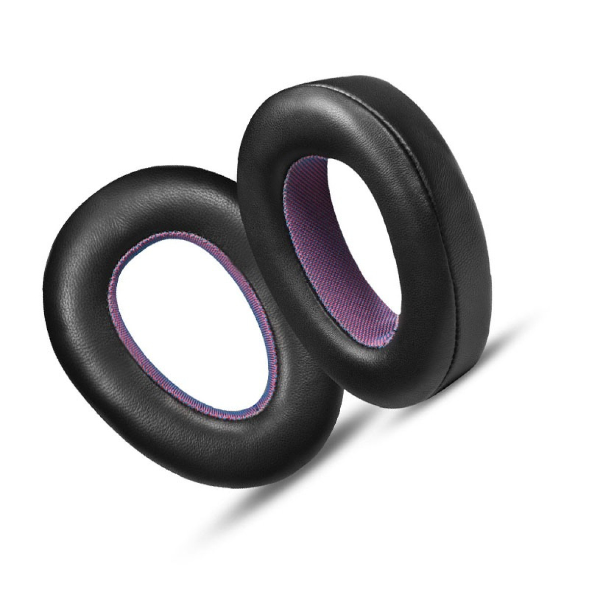 Dwie czarne poduszki nauszne do słuchawek, jedna lekko za drugą. Wewnętrzna wyściółka jest różowa i niebieska na białym tle.