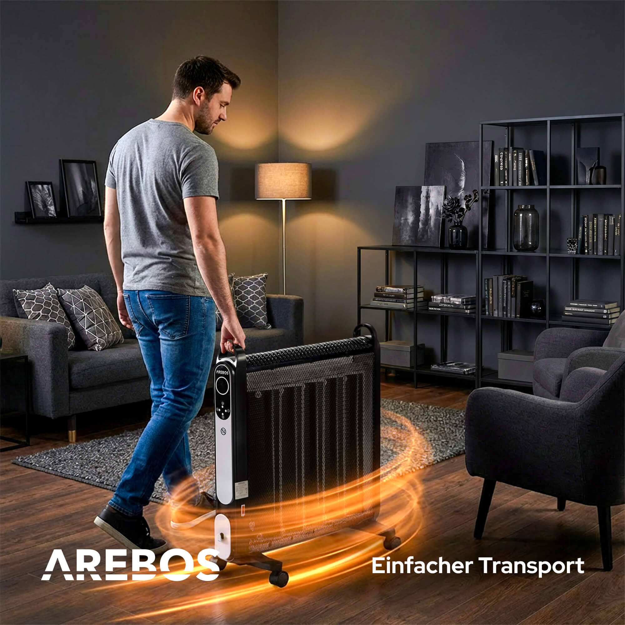 Ein Mann trägt einen schwarz-silbernen Arebos-Heizlüfter. Es befindet sich in einem modernen Wohnzimmer mit grauen Möbeln und Dekor.