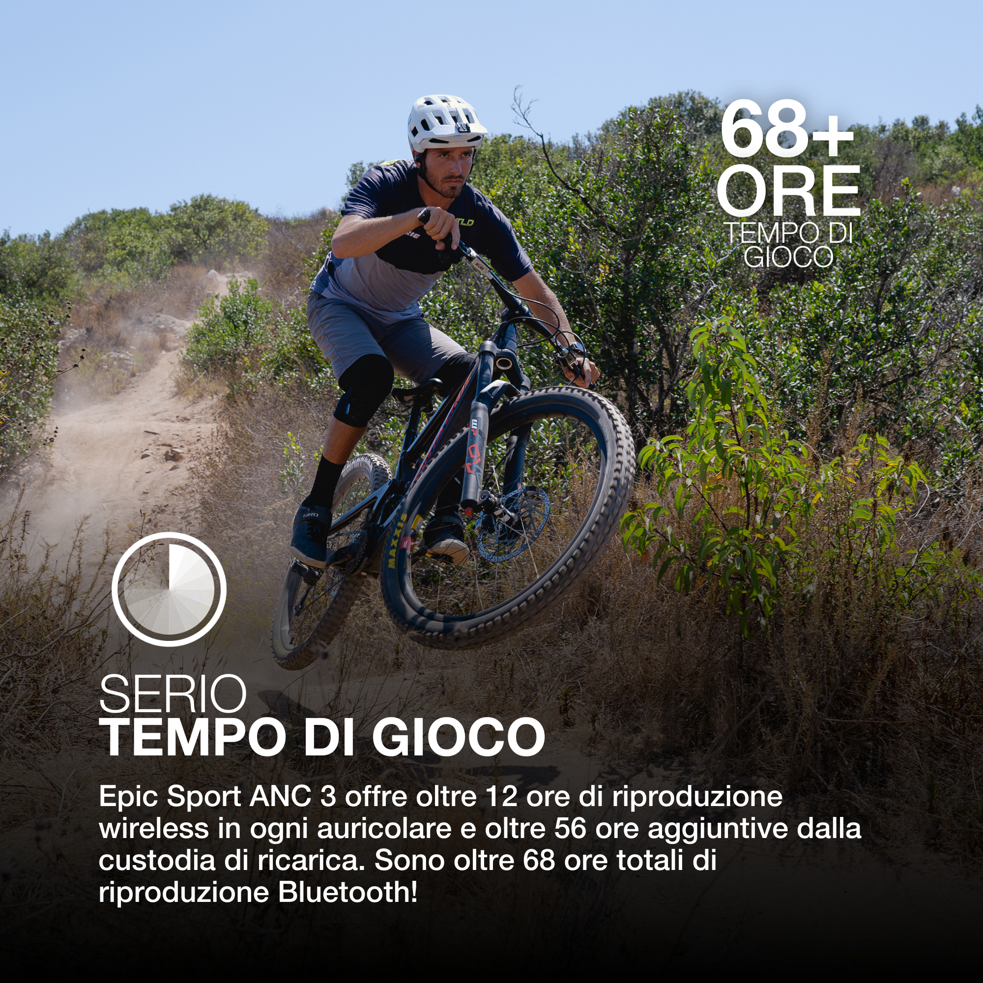 Un uomo in mountain bike salta su un sentiero sterrato. Il testo indica più di 68 ore di gioco e auricolari wireless.