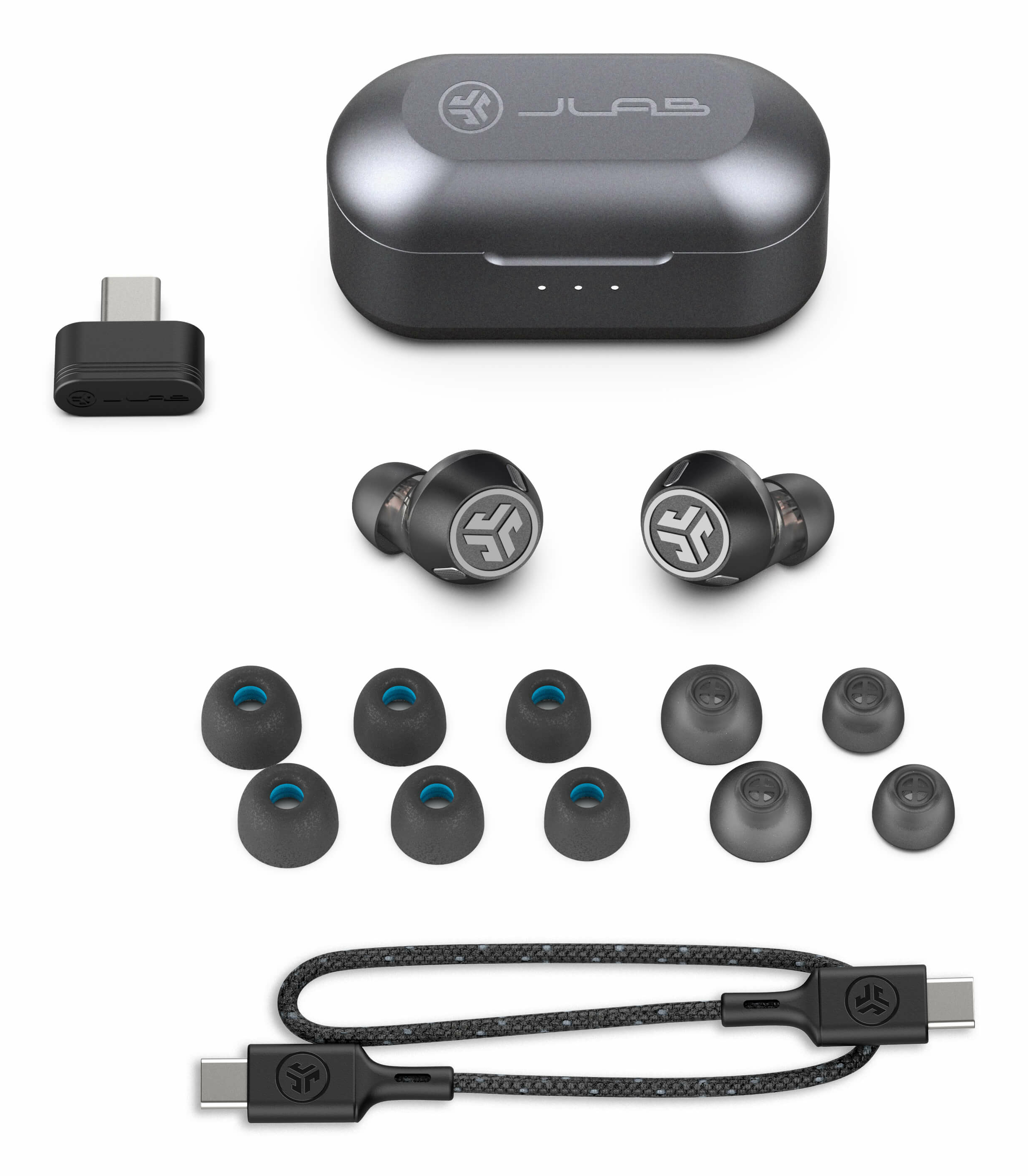 Set auricolari con custodia, adattatore, punte extra e cavo di ricarica. Colori nero e grigio. Logo JLab visibile.
