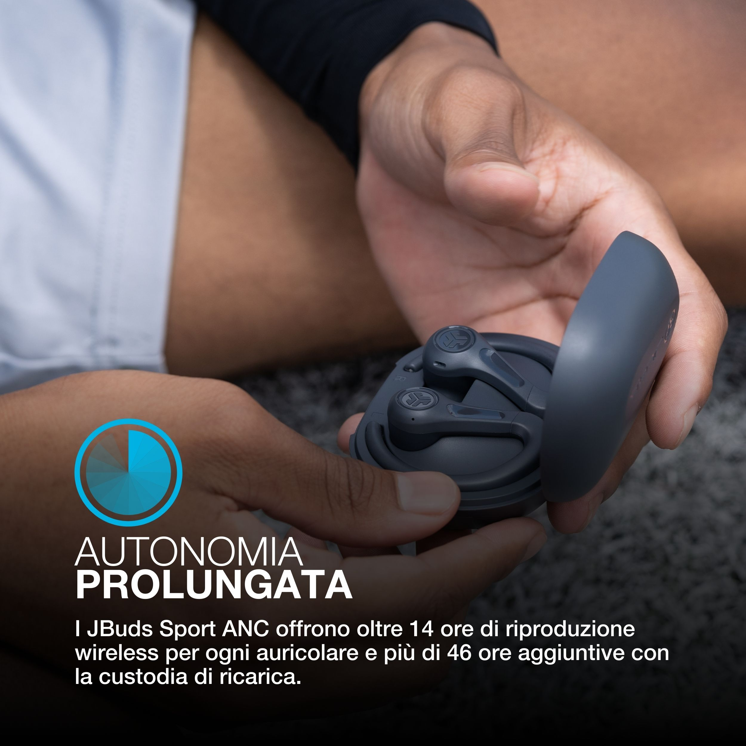 Dłonie trzymają szare etui na słuchawki z wkładkami dousznymi. Tekst: 'Wydłużona autonomia'.